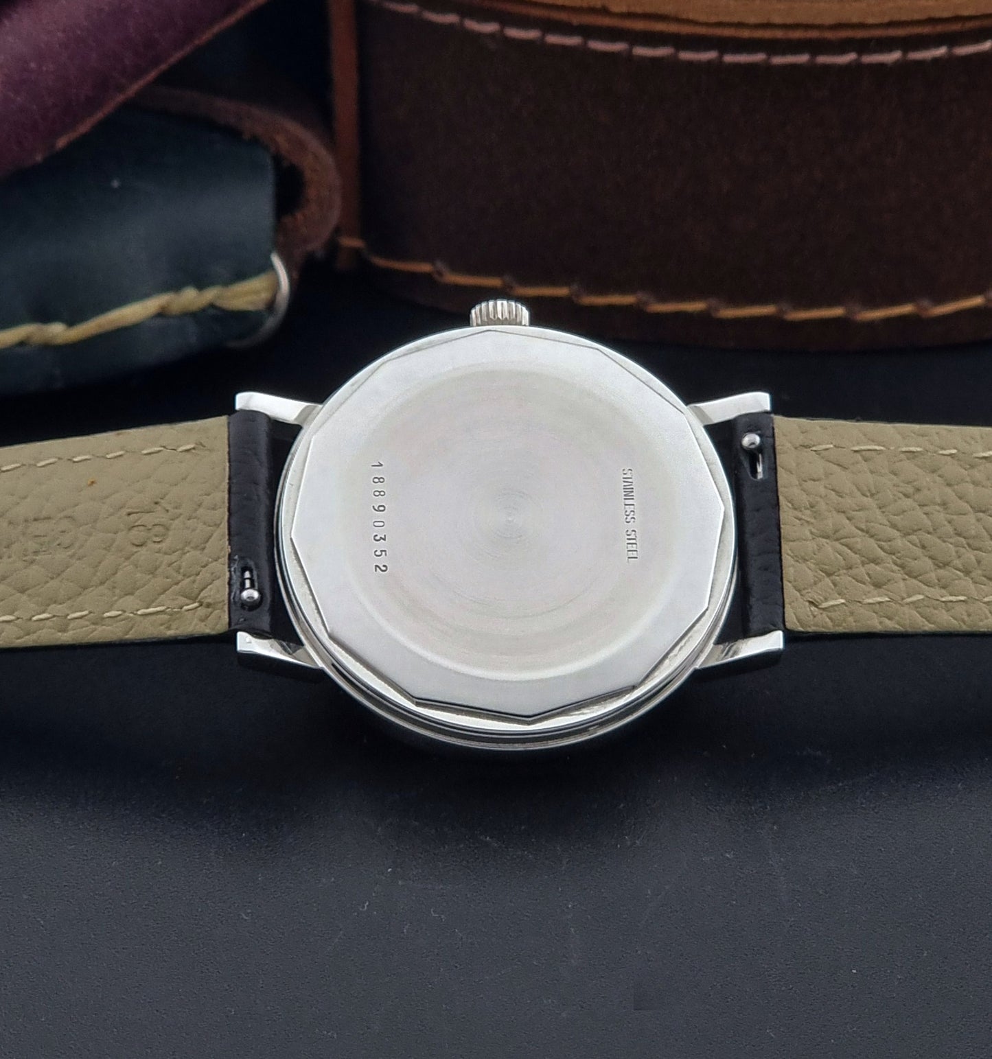 Vintage Longines Wristwatch 3029-2 with a black leather strap on a dark gray background case back view