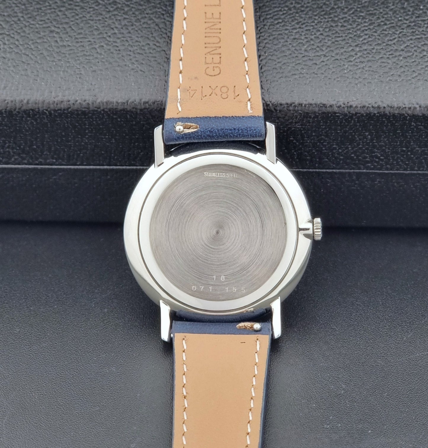 Vintage Longines Wristwatch 4127 with blue strap and silver case on a dark gray background case back view