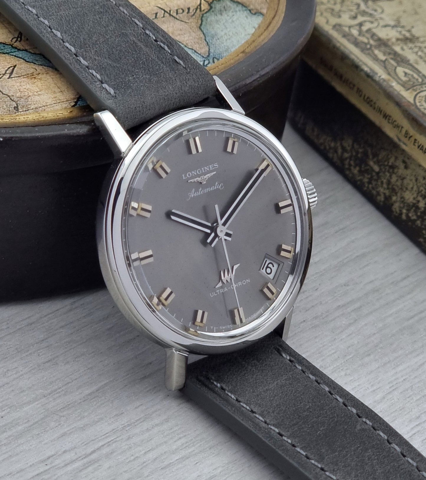 Vintage Longines Ultra-Chron Watch with gray strap and dark gray dial on a textured surface