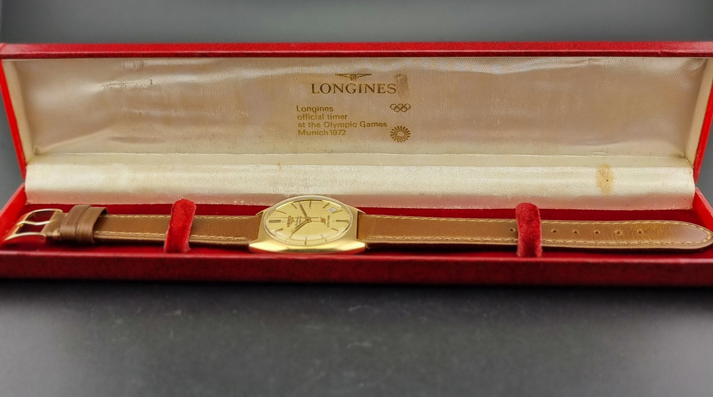 Vintage Longines Gold watch in a red Longines box on a gray background