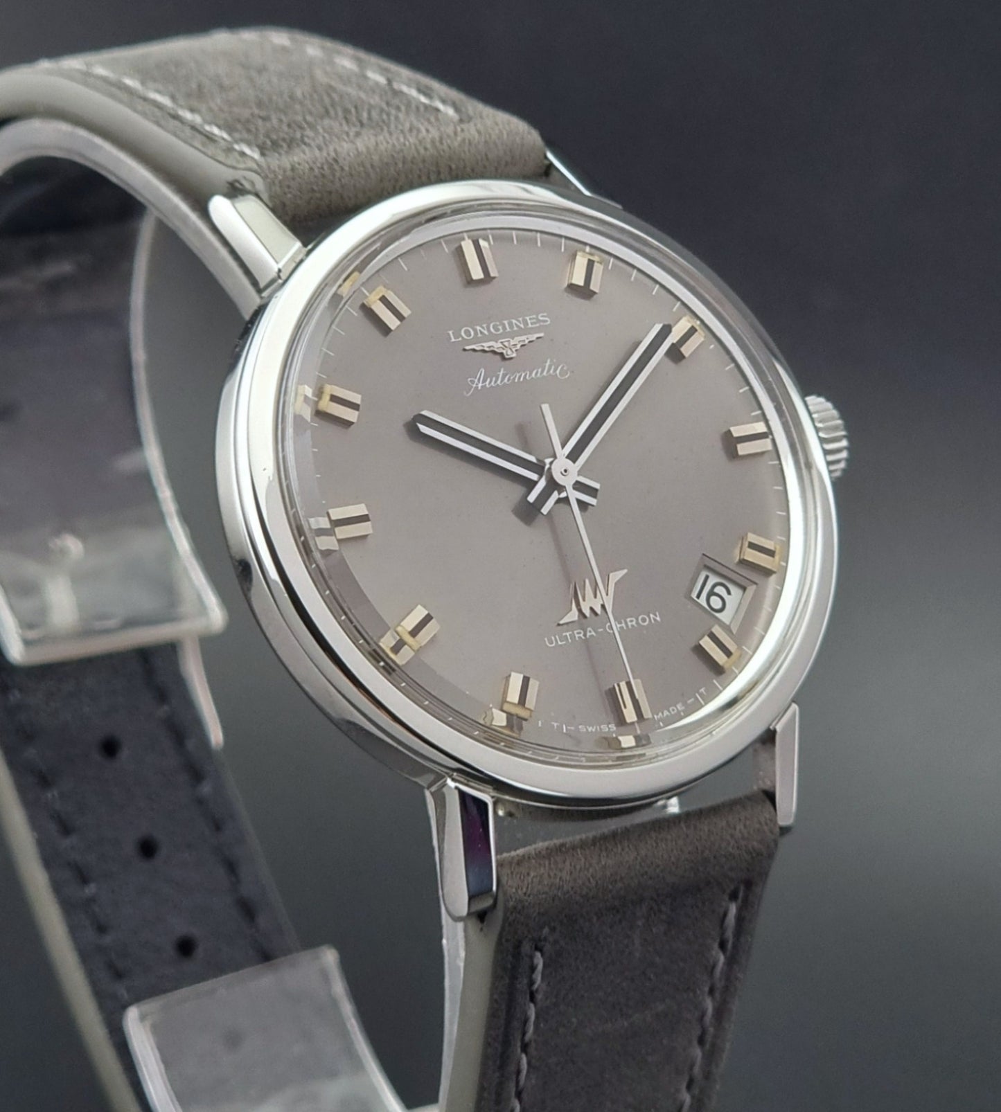 Vintage Longines Ultra-Chron watch with gray dial and leather strap on a dark background
