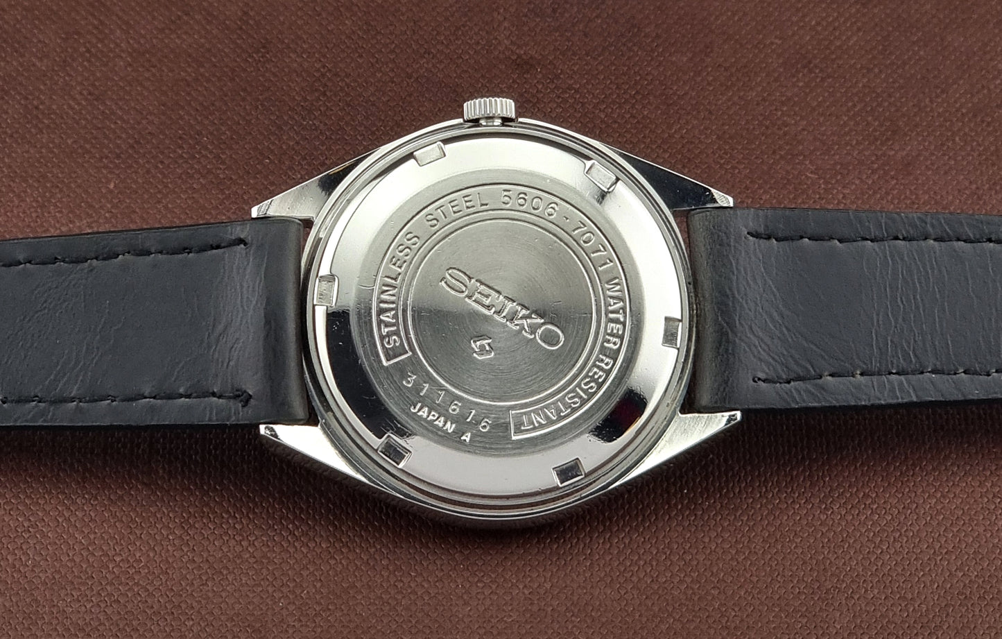 Back view of a Seiko watch on a brown leather background