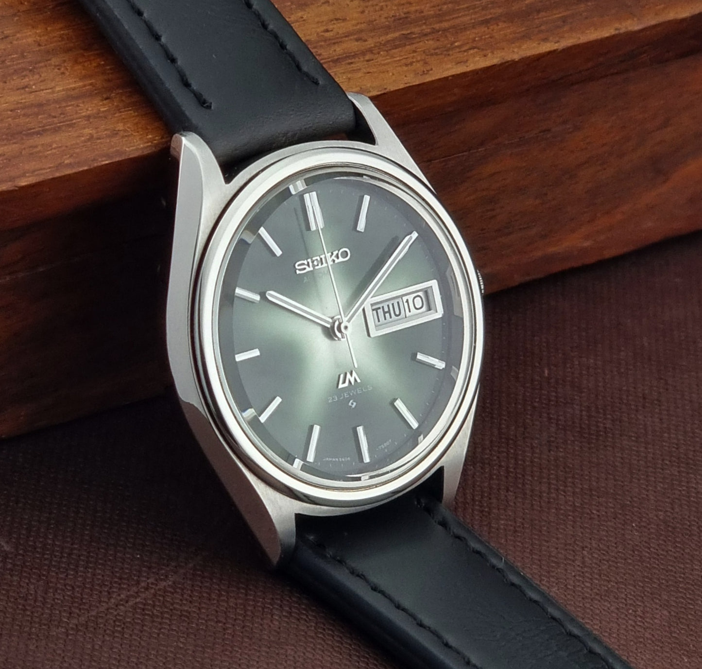 Seiko watch with black strap on a wooden surface