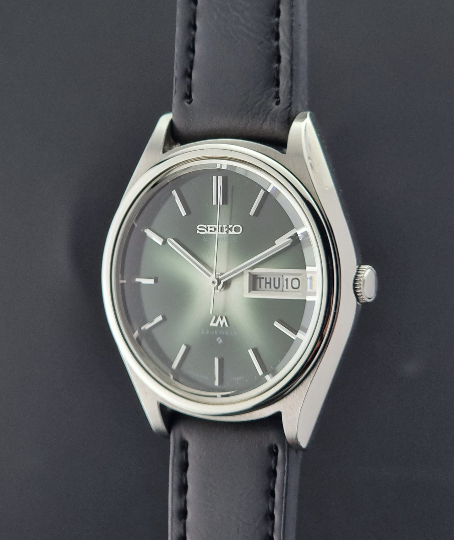 Seiko watch with a dark strap on a dark background