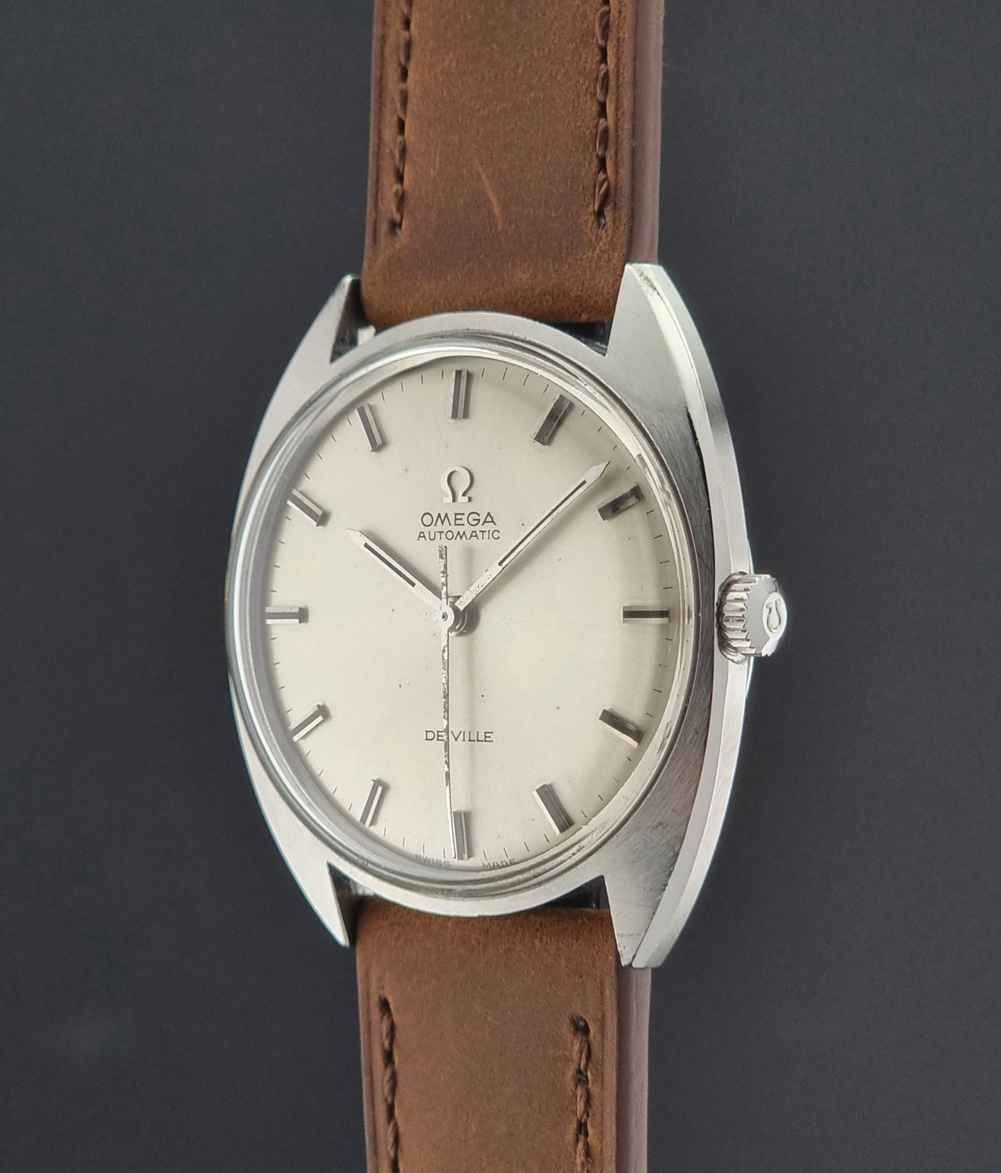 Vintage Omega watch with brown leather strap on a dark background