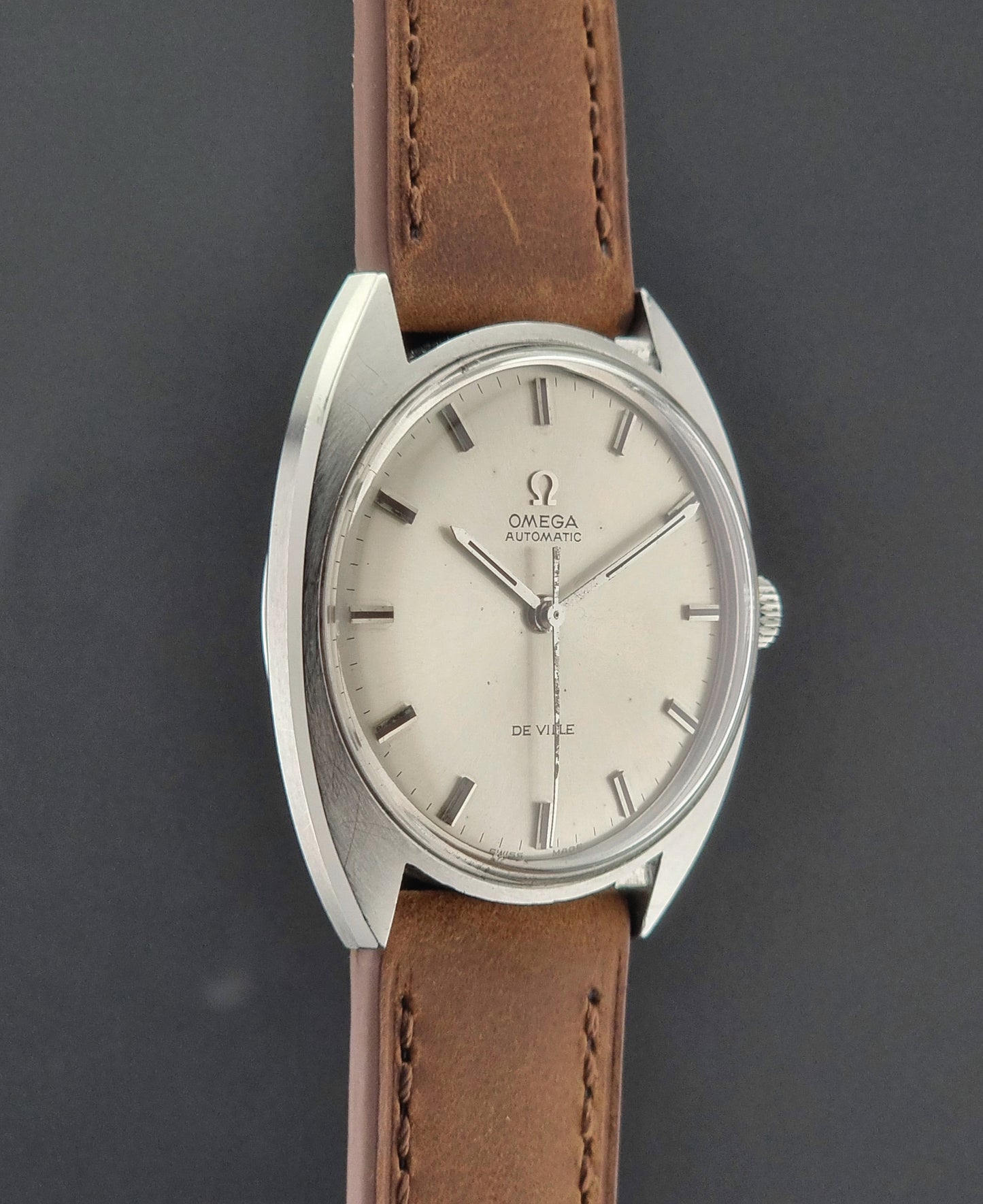 Vintage Omega watch with brown leather strap on a dark background