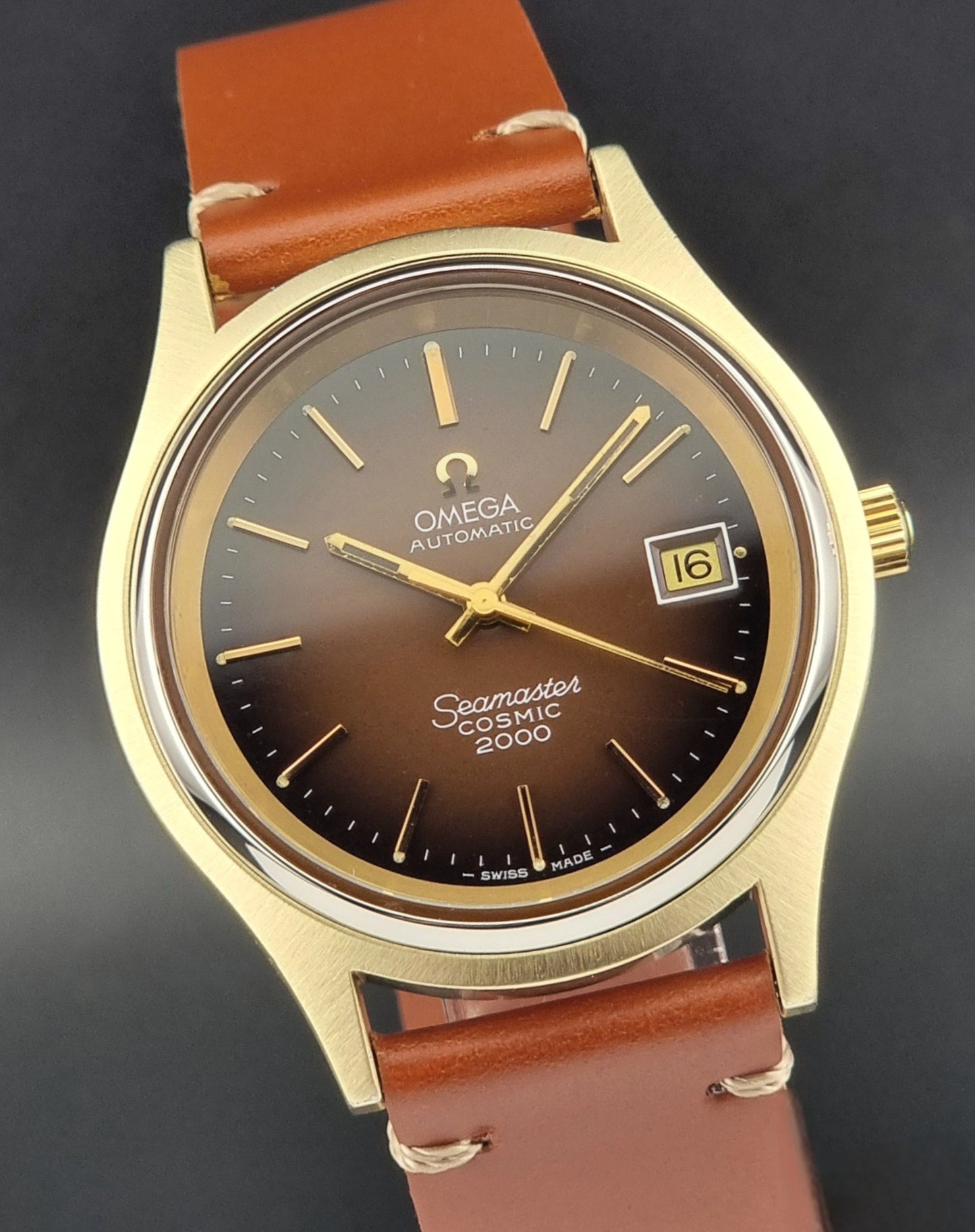 Vintage Omega Seamaster Cosmic 2000 Gold watch with brown leather strap on a dark background