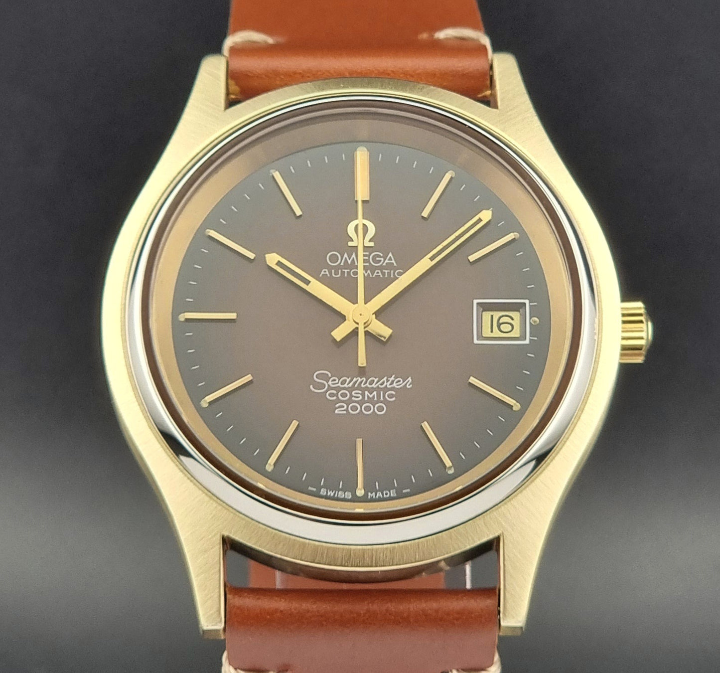 Vintage Omega Seamaster Cosmic 2000 Gold watch with brown strap on a dark background