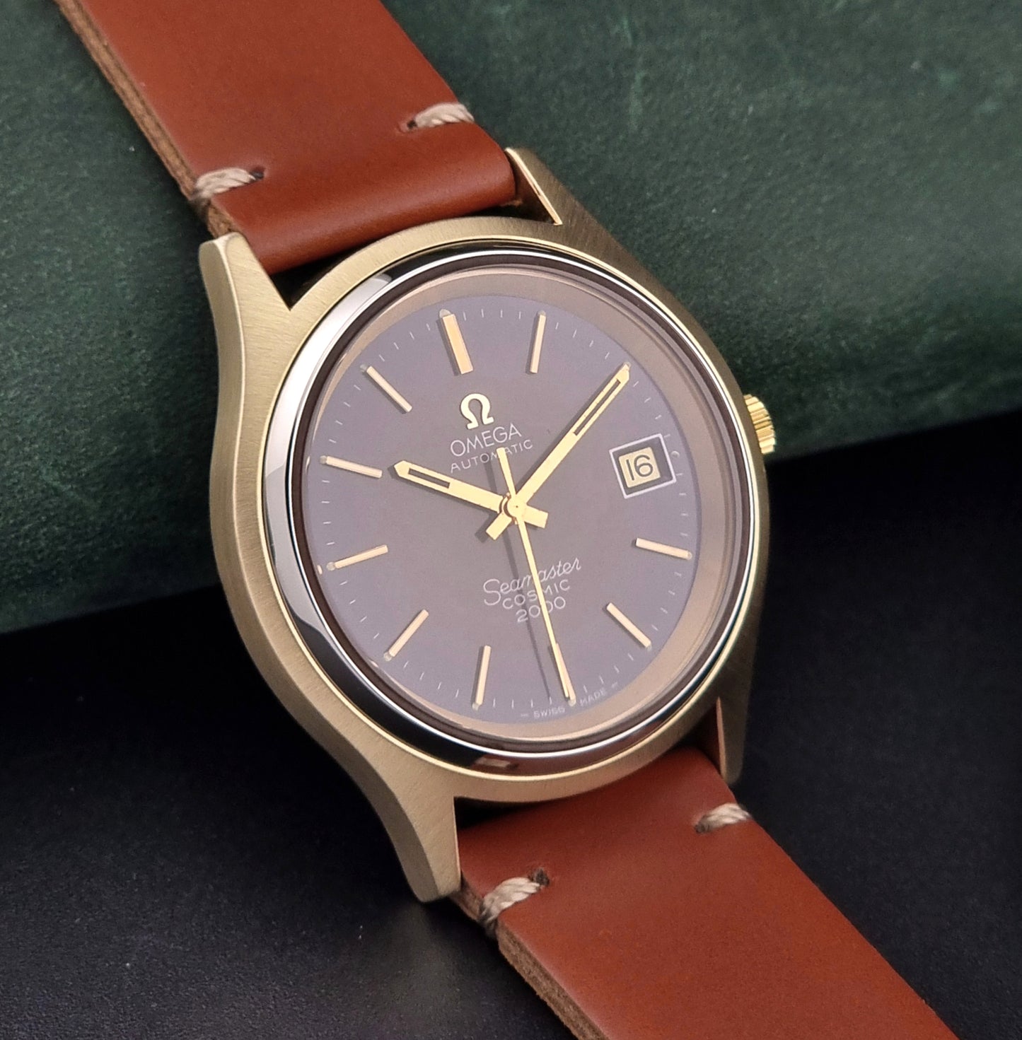 Vintage Omega Seamaster Cosmic 2000 watch with brown leather strap on a dark background