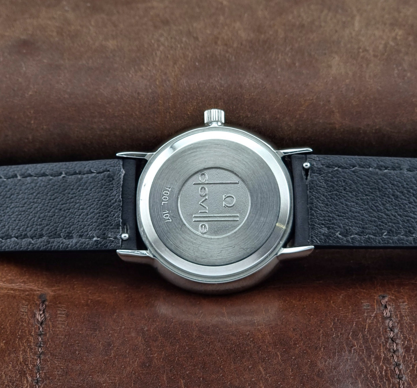 Vintage Omega de-ville wristwatch on a brown background case back view