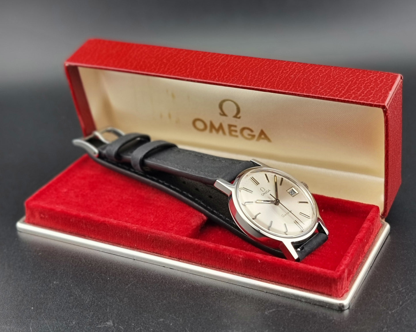 Vintage Omega Geneve watch in a red box on a dark background