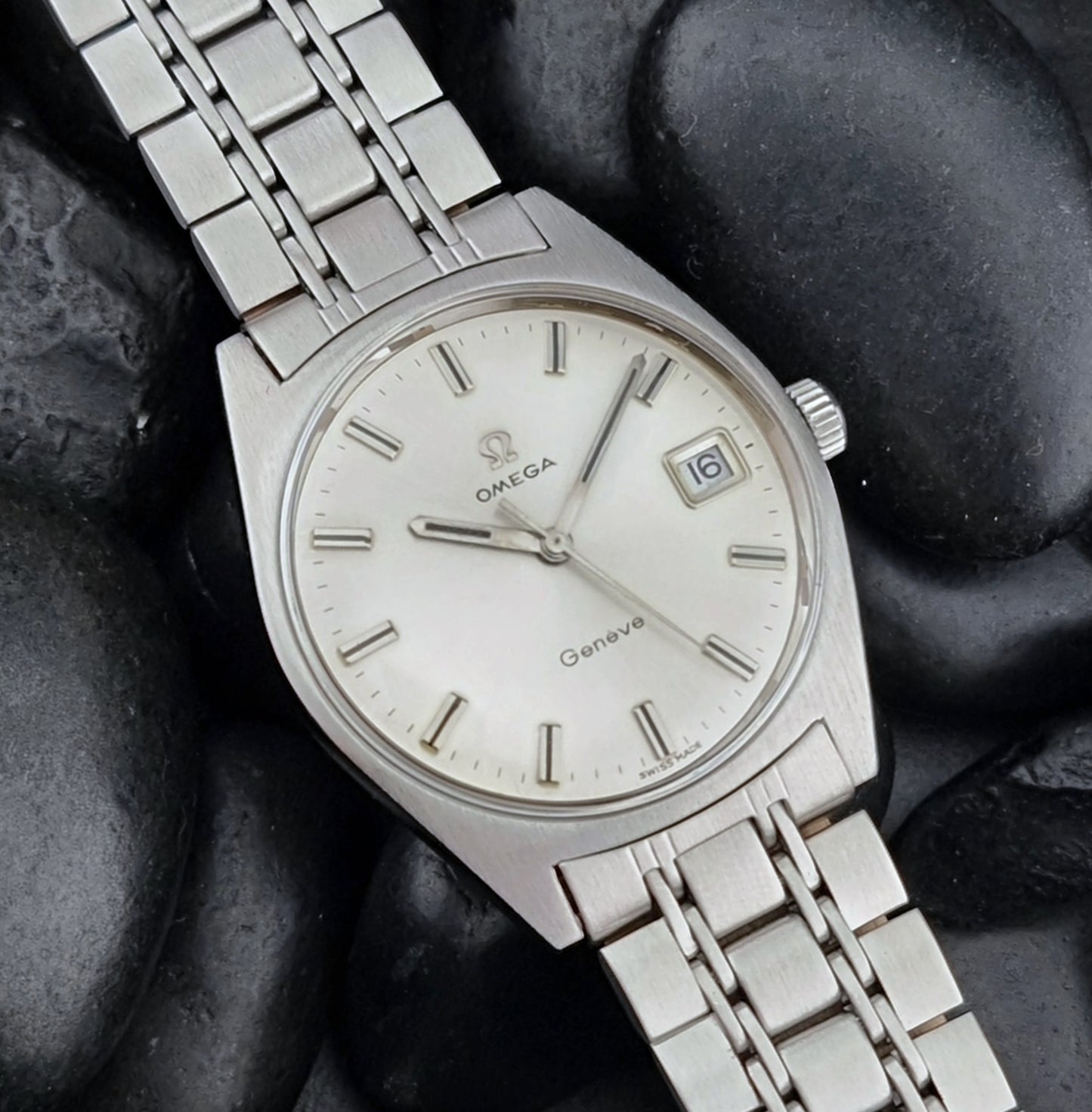 Vintage Omega Geneve watch on a dark stone surface
