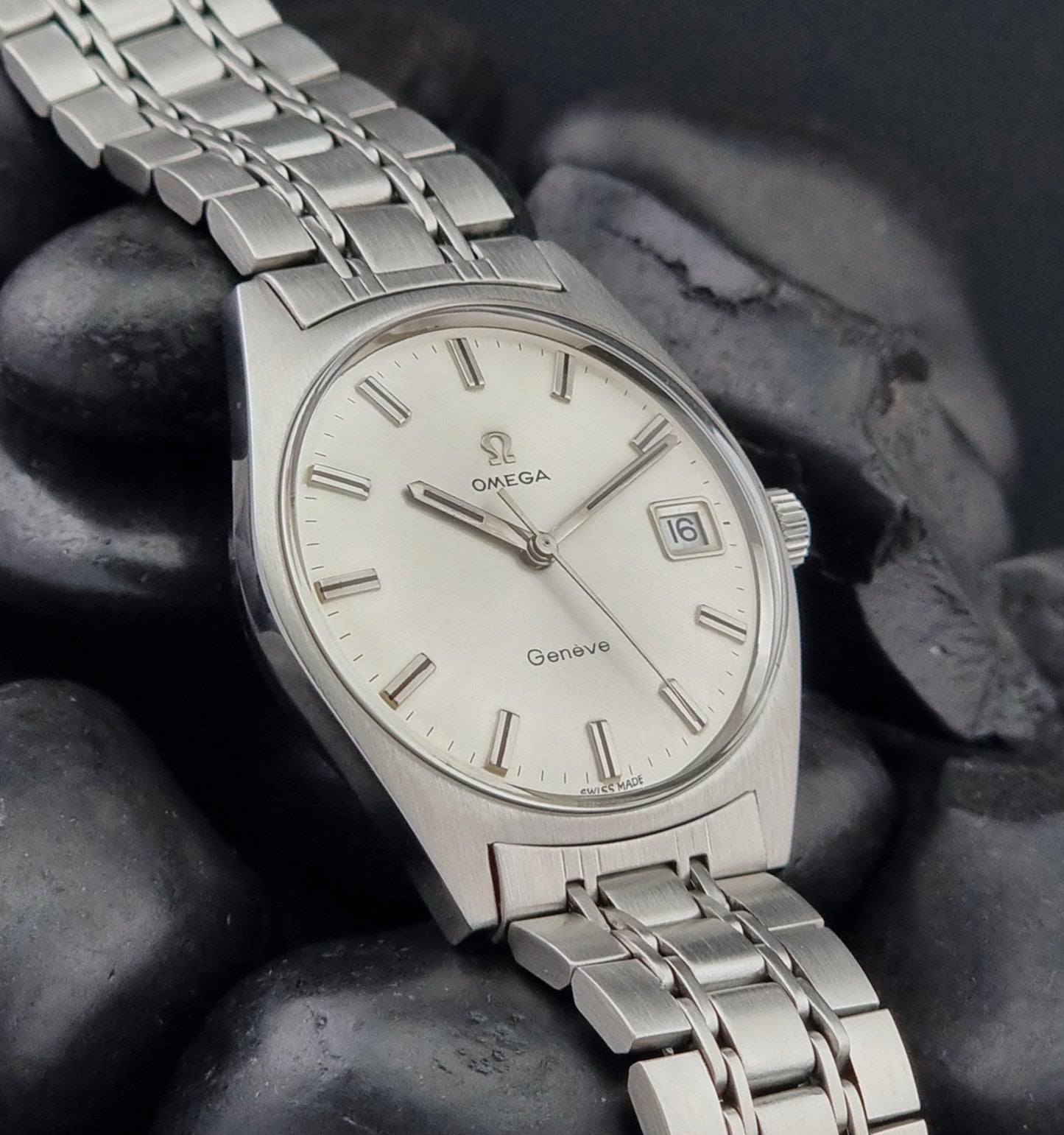 Vintage Omega Geneve watch on a dark stone surface