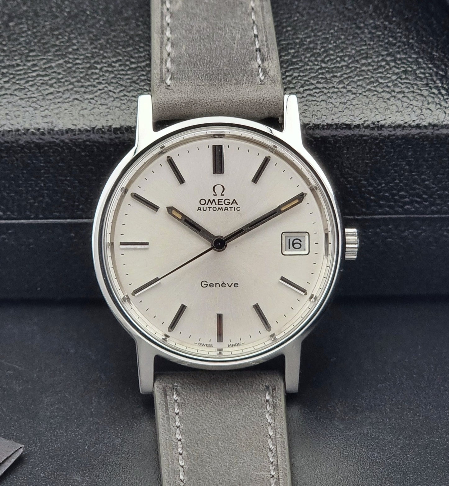 Vintage Omega watch with a gray strap on a dark textured background