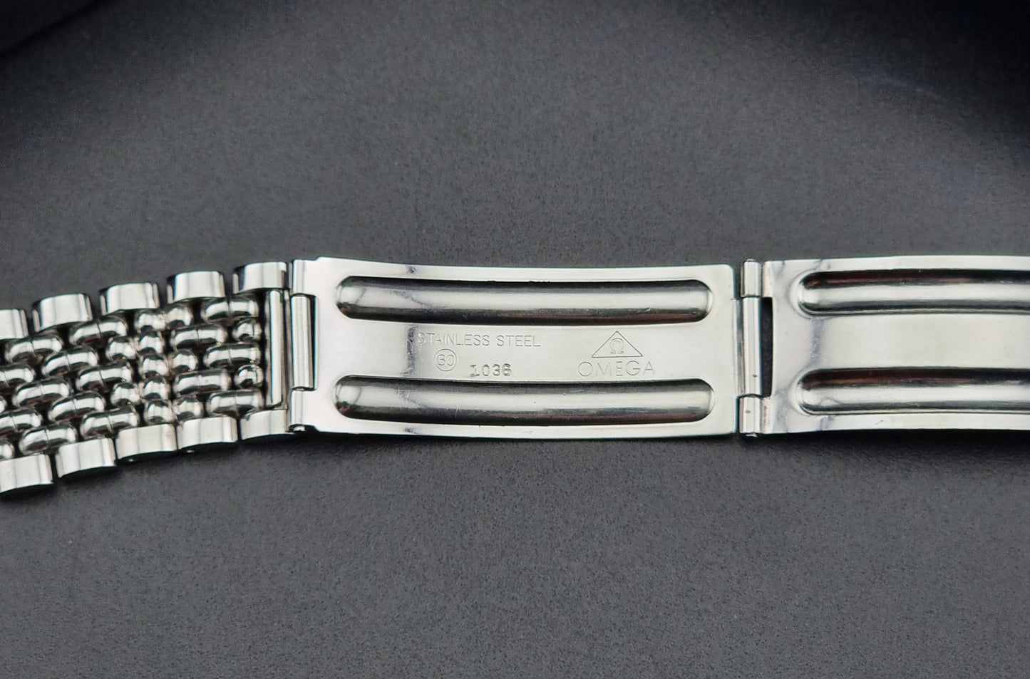 Vintage Omega Wristwatch Seamaster 166.010 watch on a dark gray background clasp view