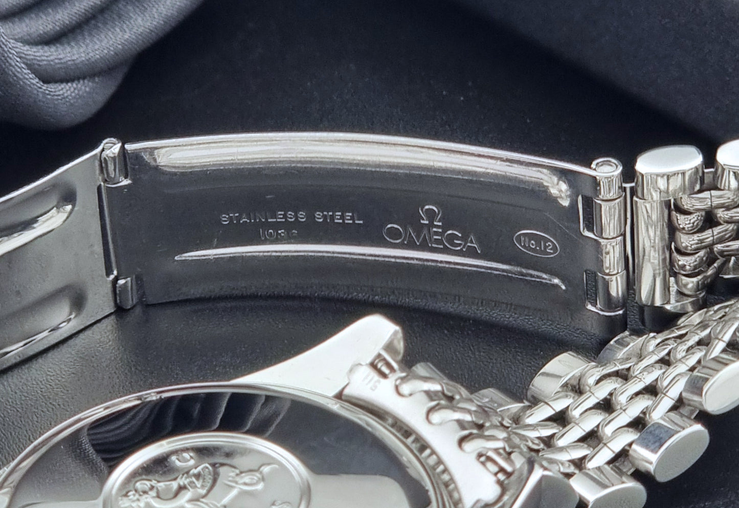 Vintage Omega Wristwatch Seamaster 166.010 Chronometer with stainless steel bracelet on a dark background clasp view