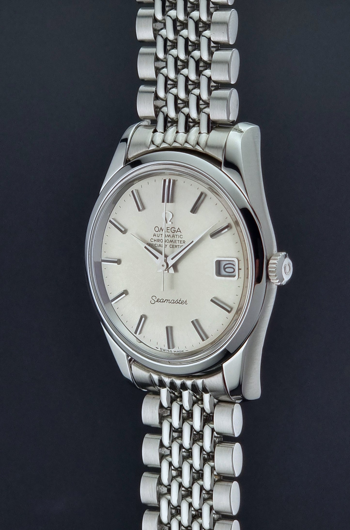 Vintage Omega Wristwatch Seamaster 166.010 Chronometer with stainless steel bracelet on a dark background close side profile view