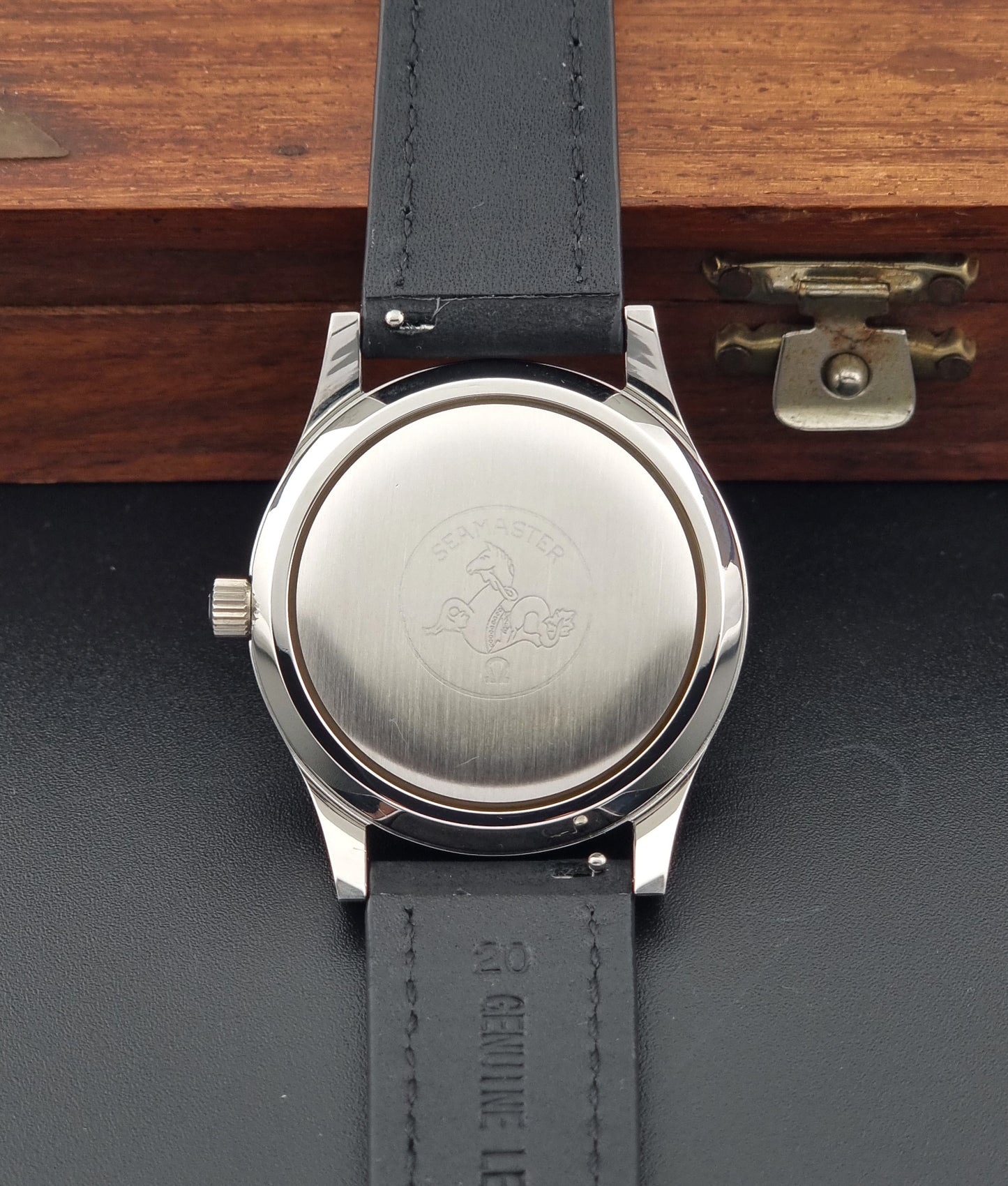 Vintage Omega Wristwatch Seamaster Cosmic 2000 Jumbo 166.128 watch with black leather strap on a wooden surface case back view