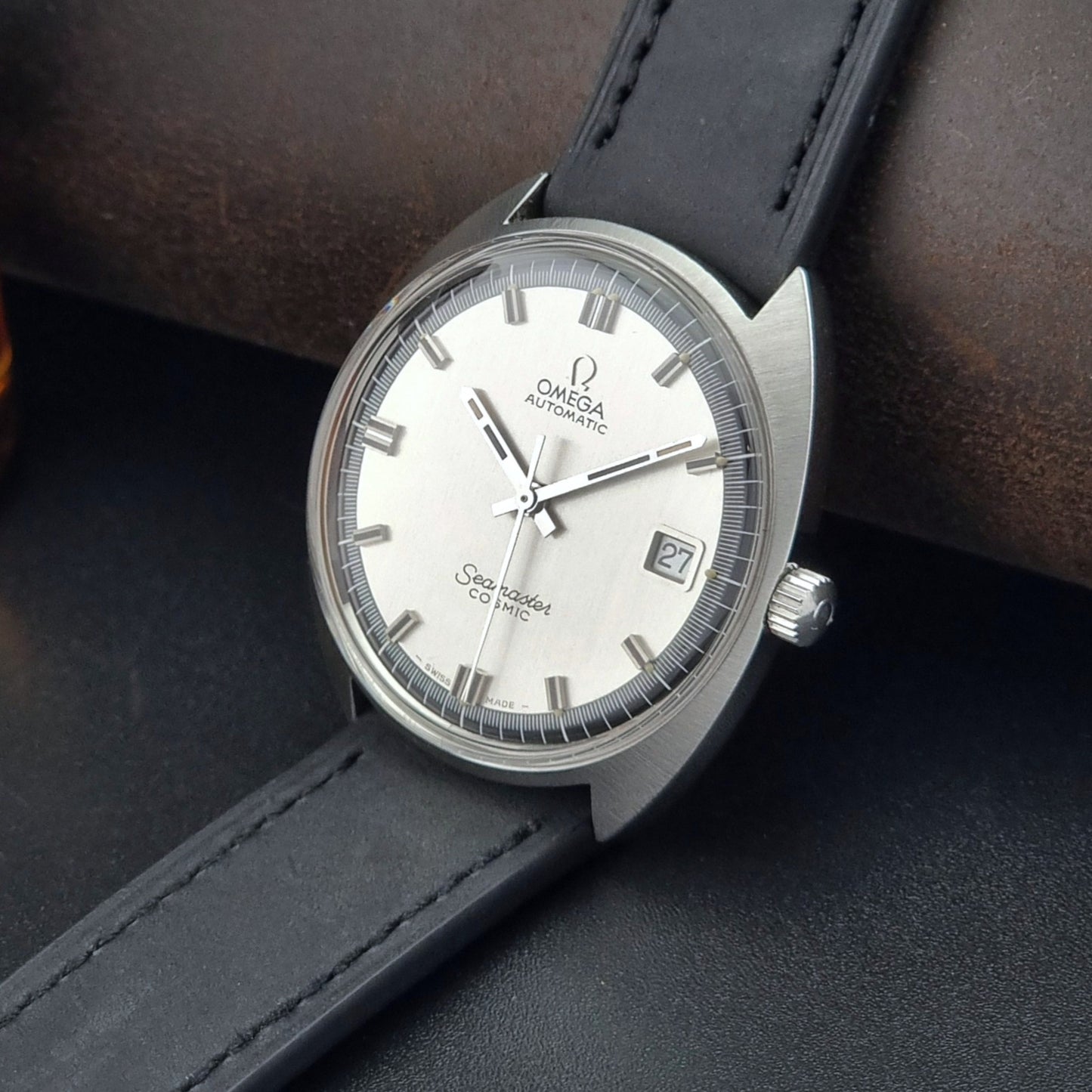 Vintage Omega Seamaster Cosmic watch with black leather strap on a dark background