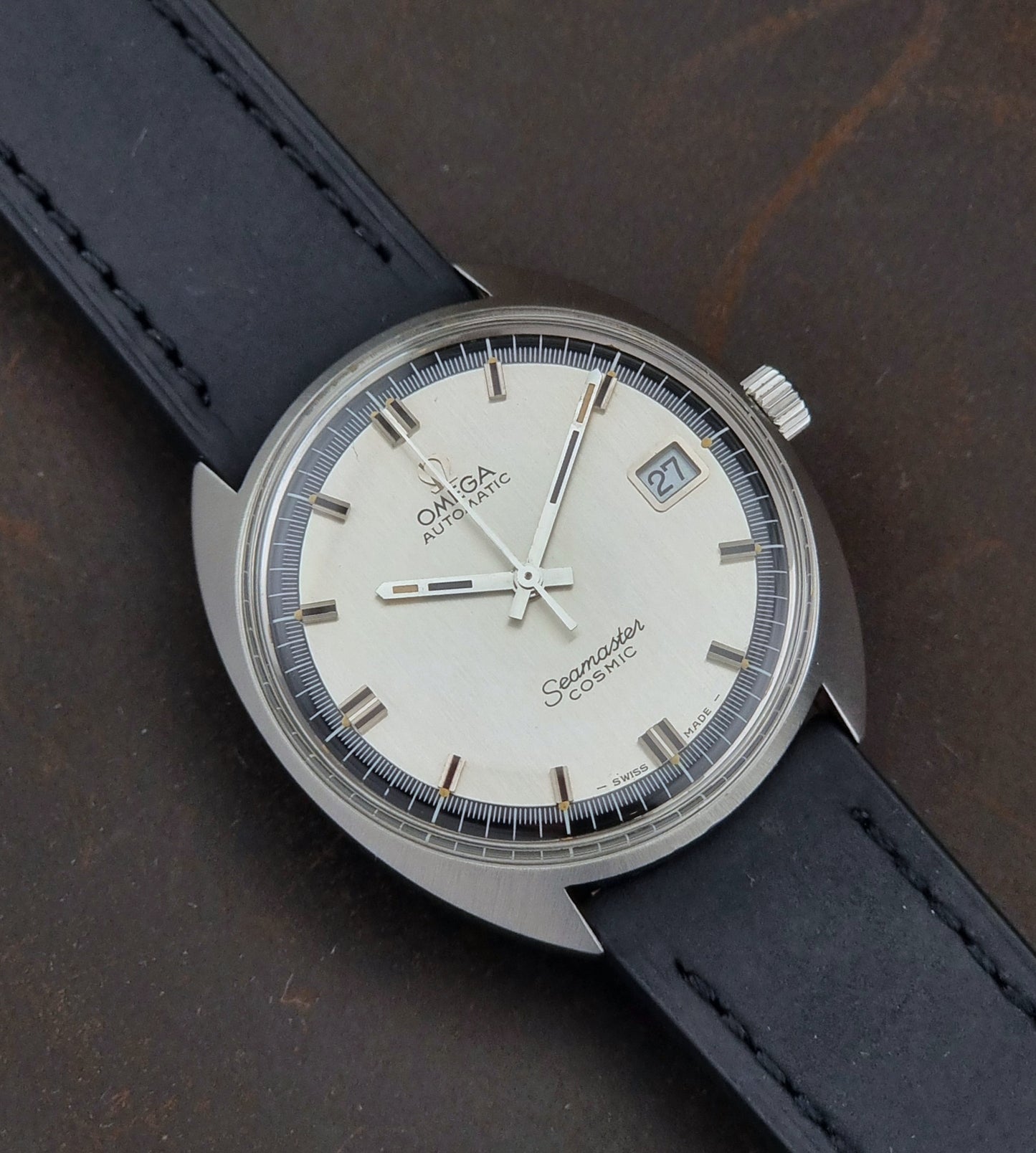 Vintage Omega Seamaster Cosmic watch with a black strap on a dark surface