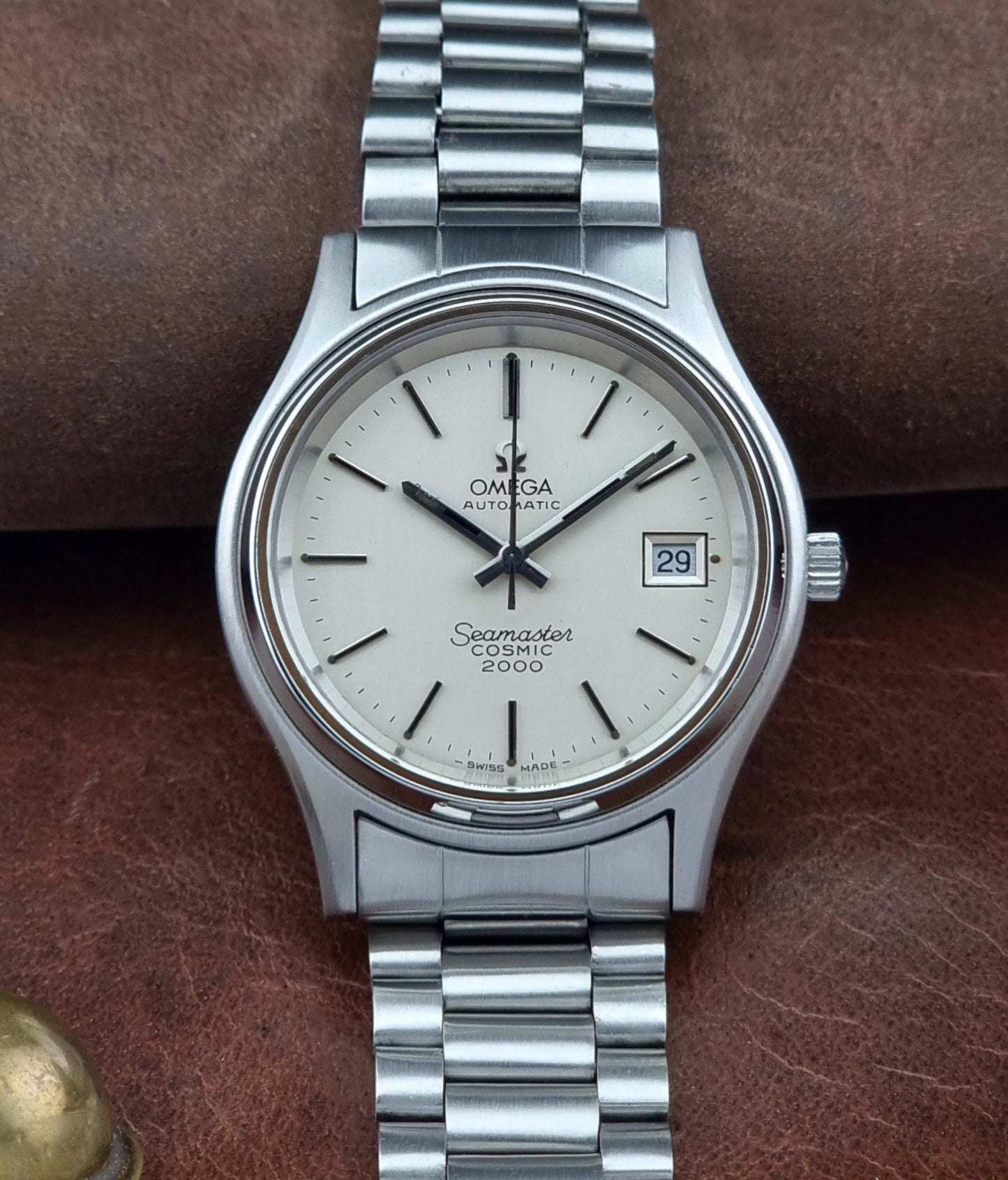 Vintage Omega Seamaster watch with white dial on a brown leather surface