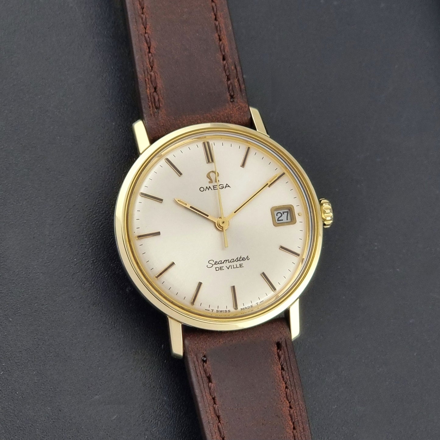 Vintage Omega Wristwatch Seamaster De-ville 136.020 gold capped with brown strap on a dark background front view