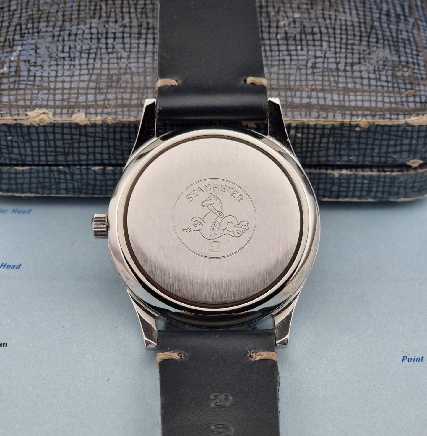 Omega Seamaster Cosmic 2000 166.128case back logo on a textured surface