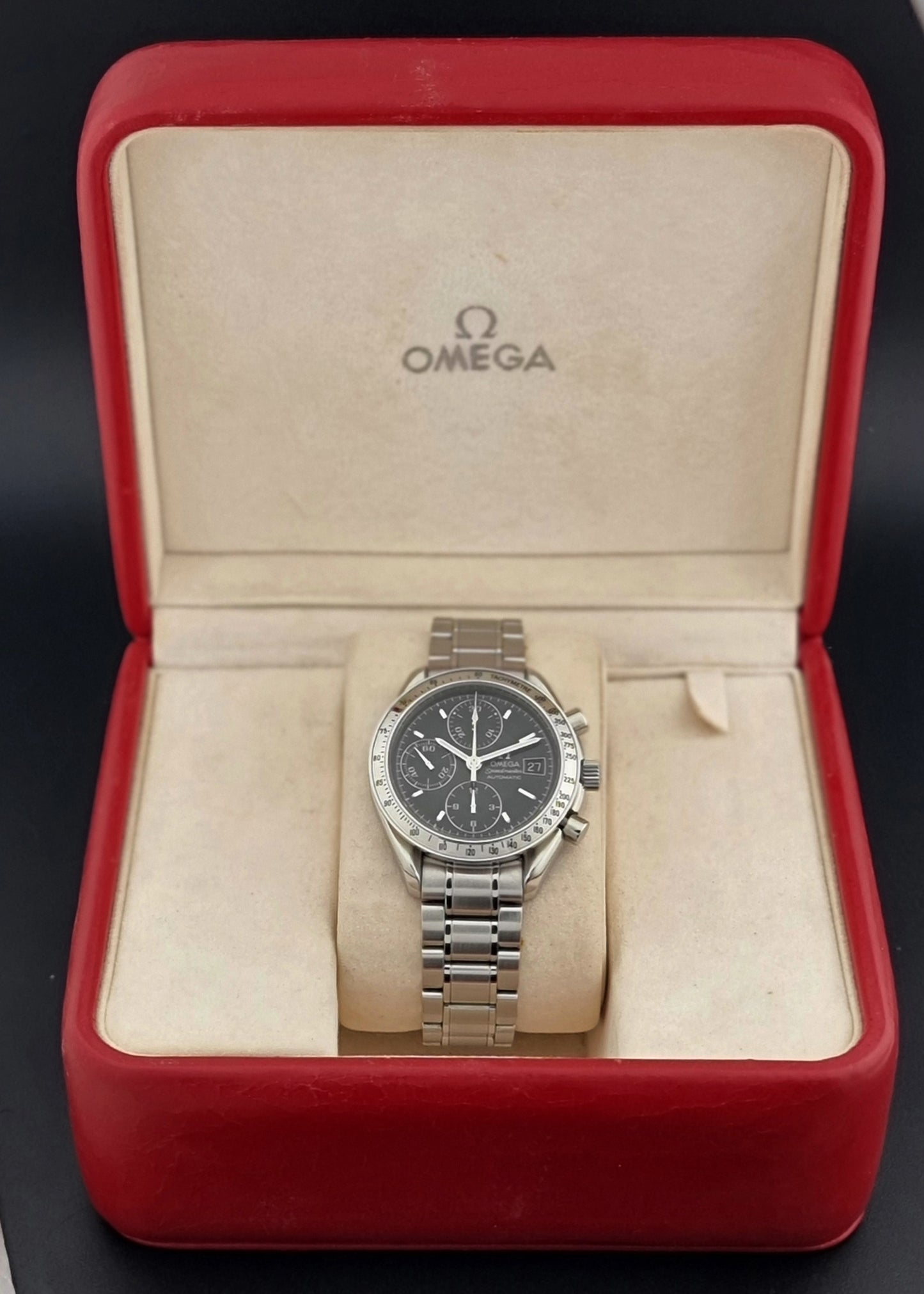 Omega Speedmaster watch in a red Omega box on a black background