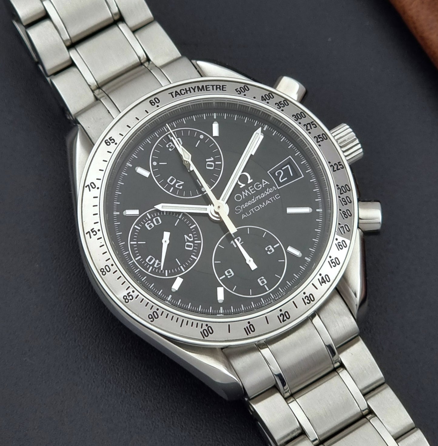 Omega Speedmaster watch with a dark face on a dark background