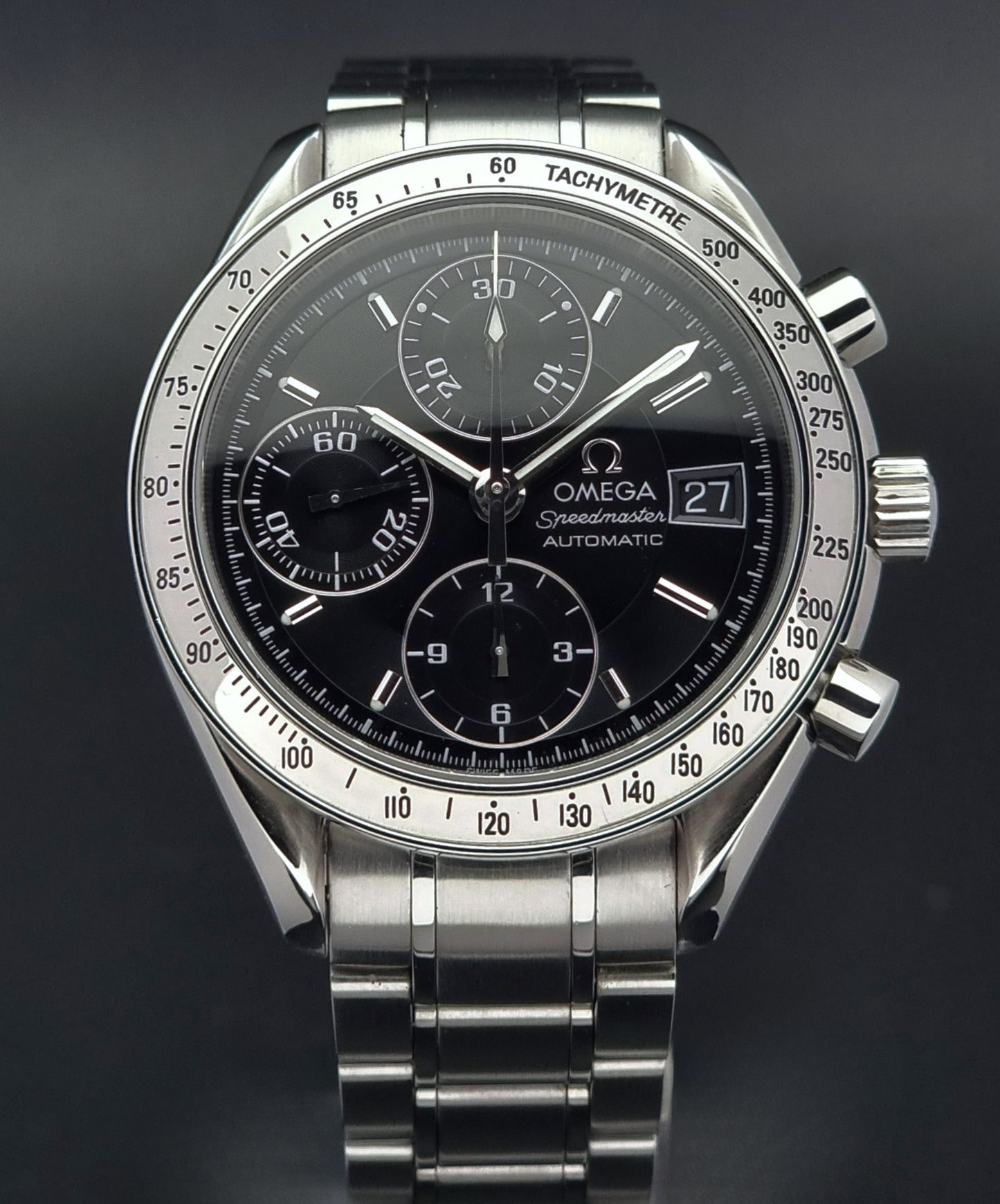 Omega Speedmaster watch with black dial on a dark background
