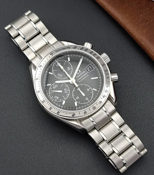 Omega Speedmaster watch with a dark face on a gray background