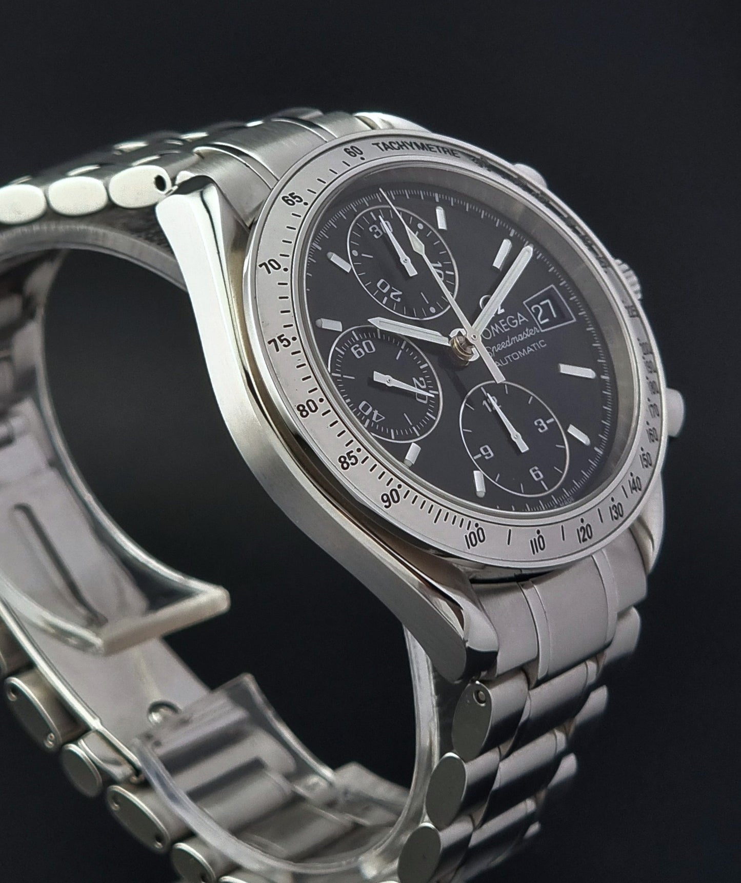 Omega Speedmaster watch with a black face on a dark background