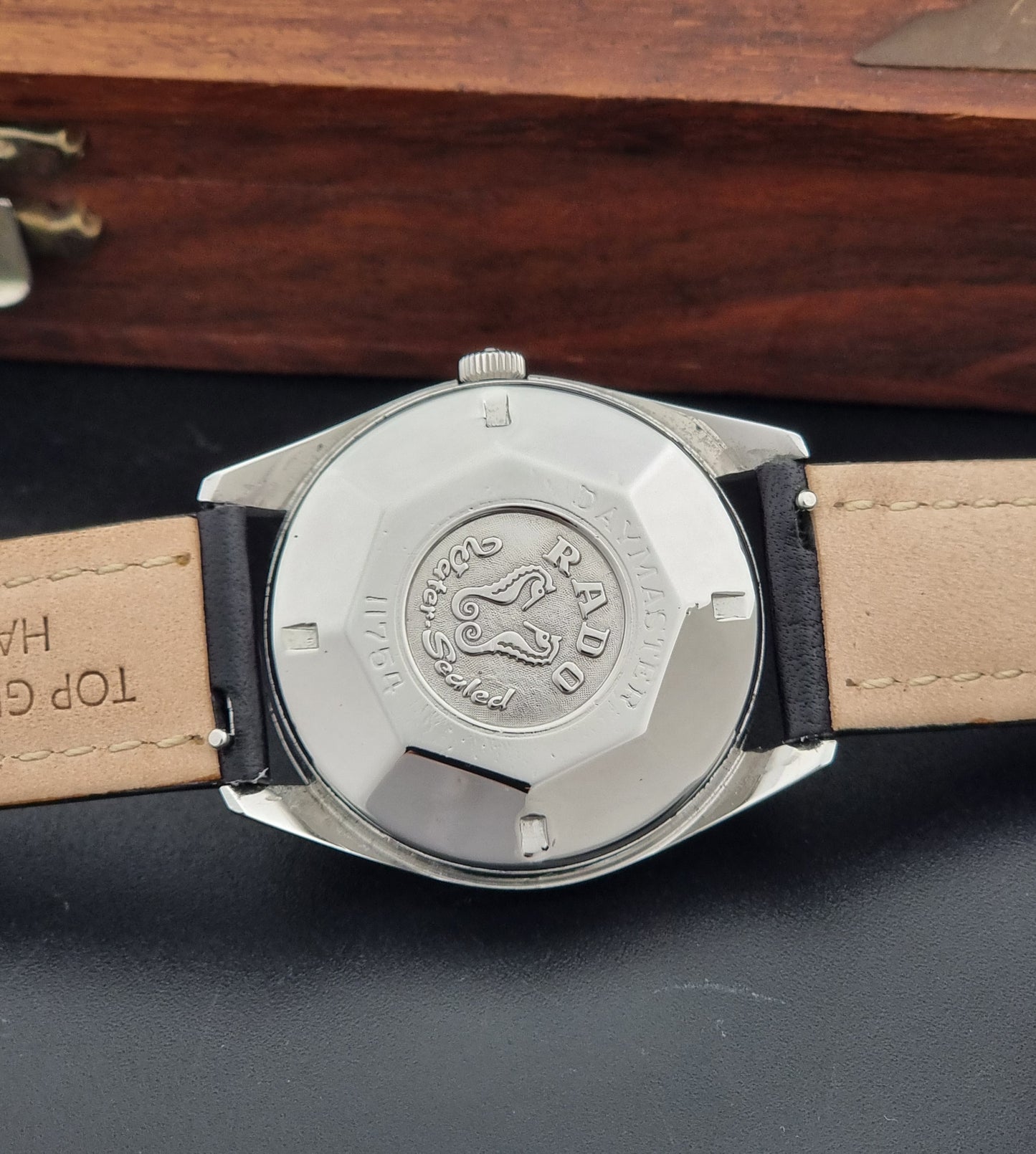 Vintage Rado wristwatch Daymaster 11754 with black leather strap on a dark surface case back view