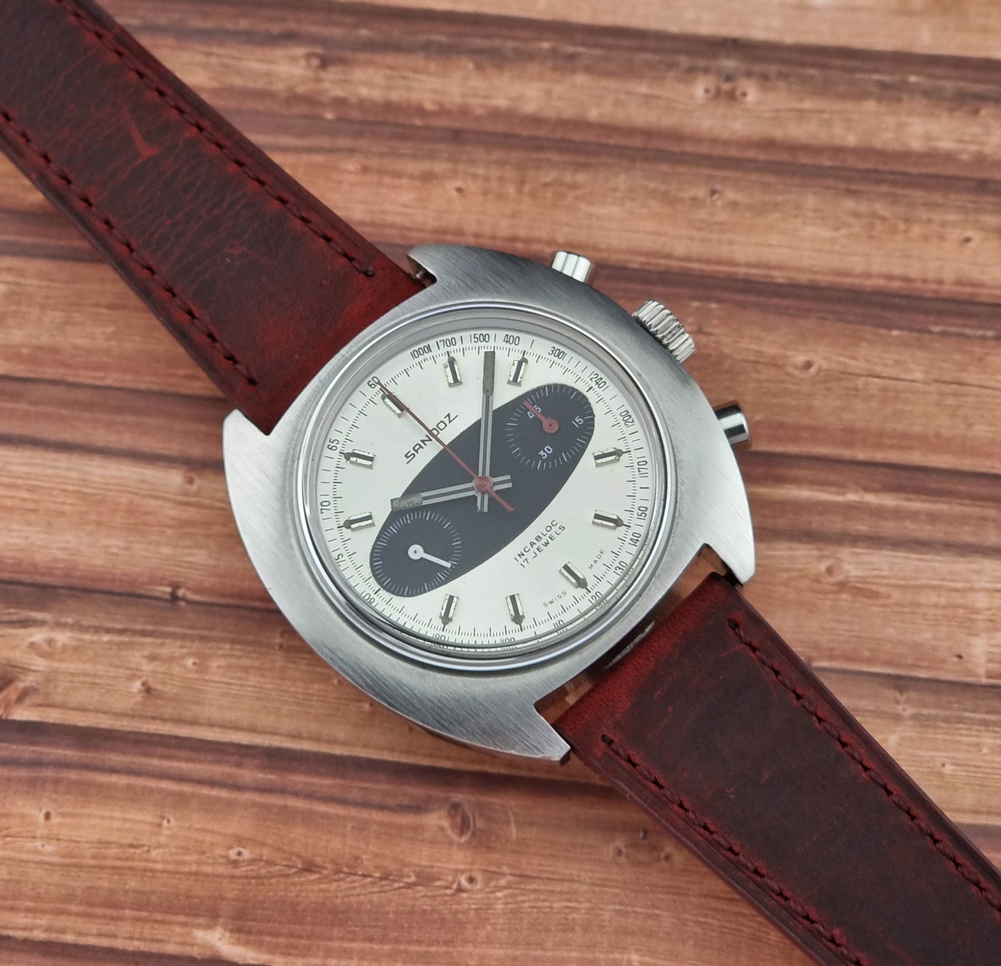 Sandoz Wristwatch with brown leather strap on a wooden surface
