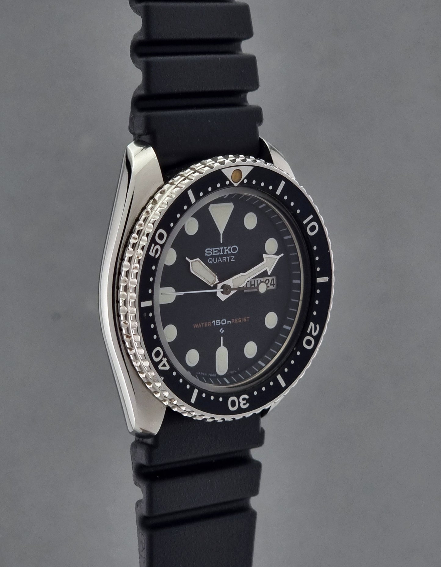 Seiko Quartz Dive watch 7548-7000 with black strap and black dial on a gray background