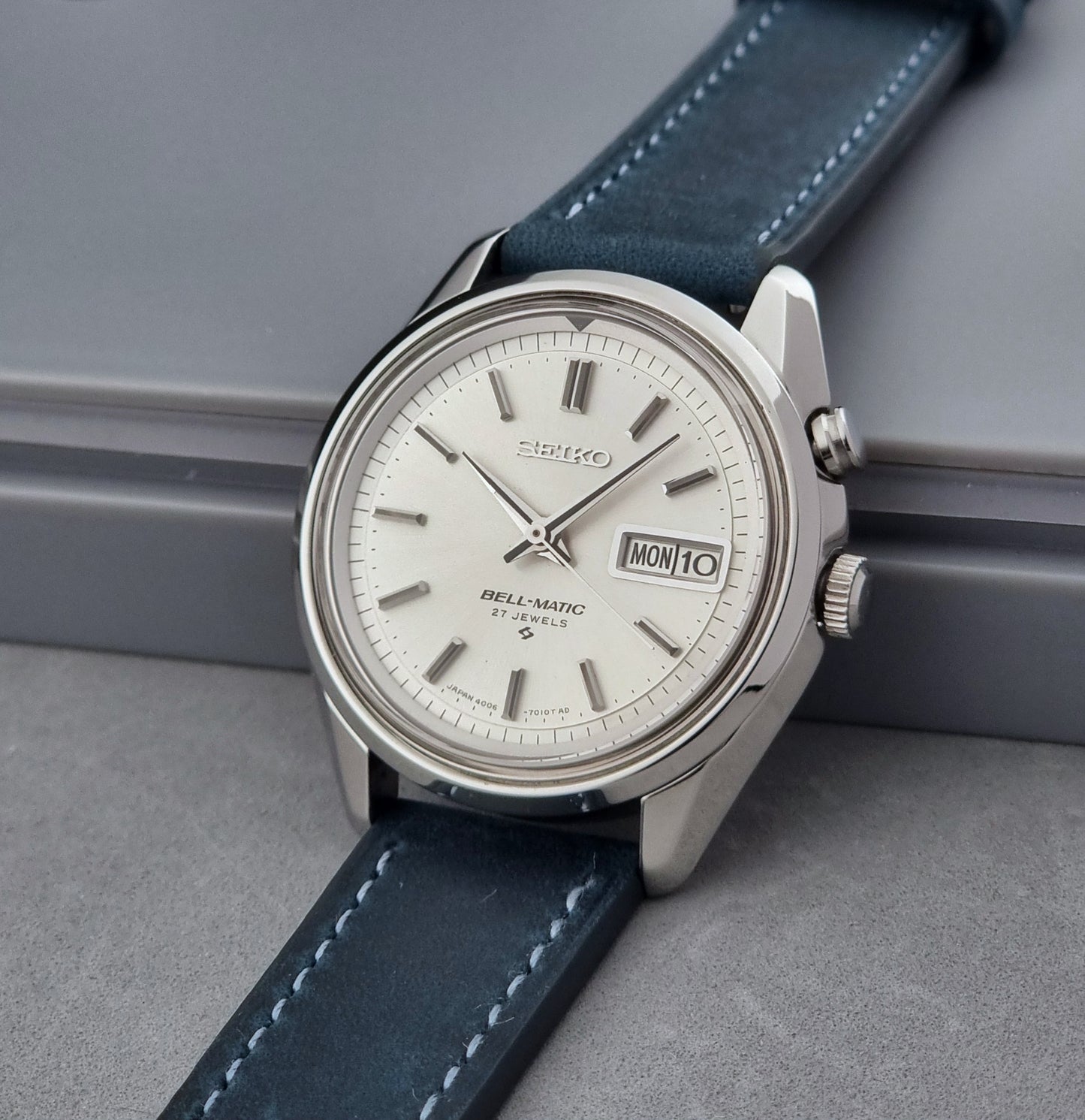 Vintage Seiko Alarm Watch Bell-Matic 4006-7010 with a blue strap on a grey background crown side profile