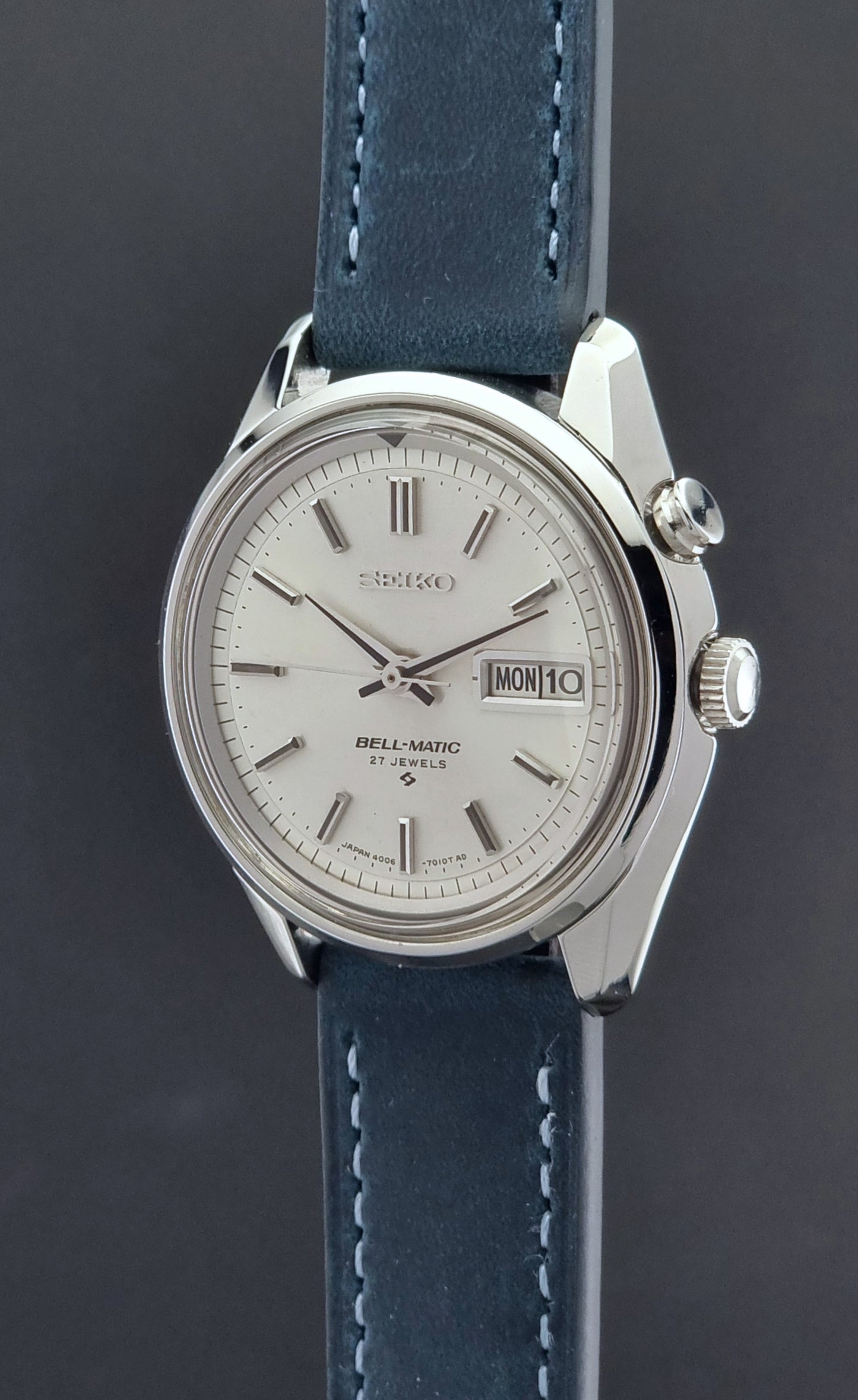 Vintage Seiko Alarm Watch Bell-Matic 4006-7010 with a blue strap on a grey background crown side profile