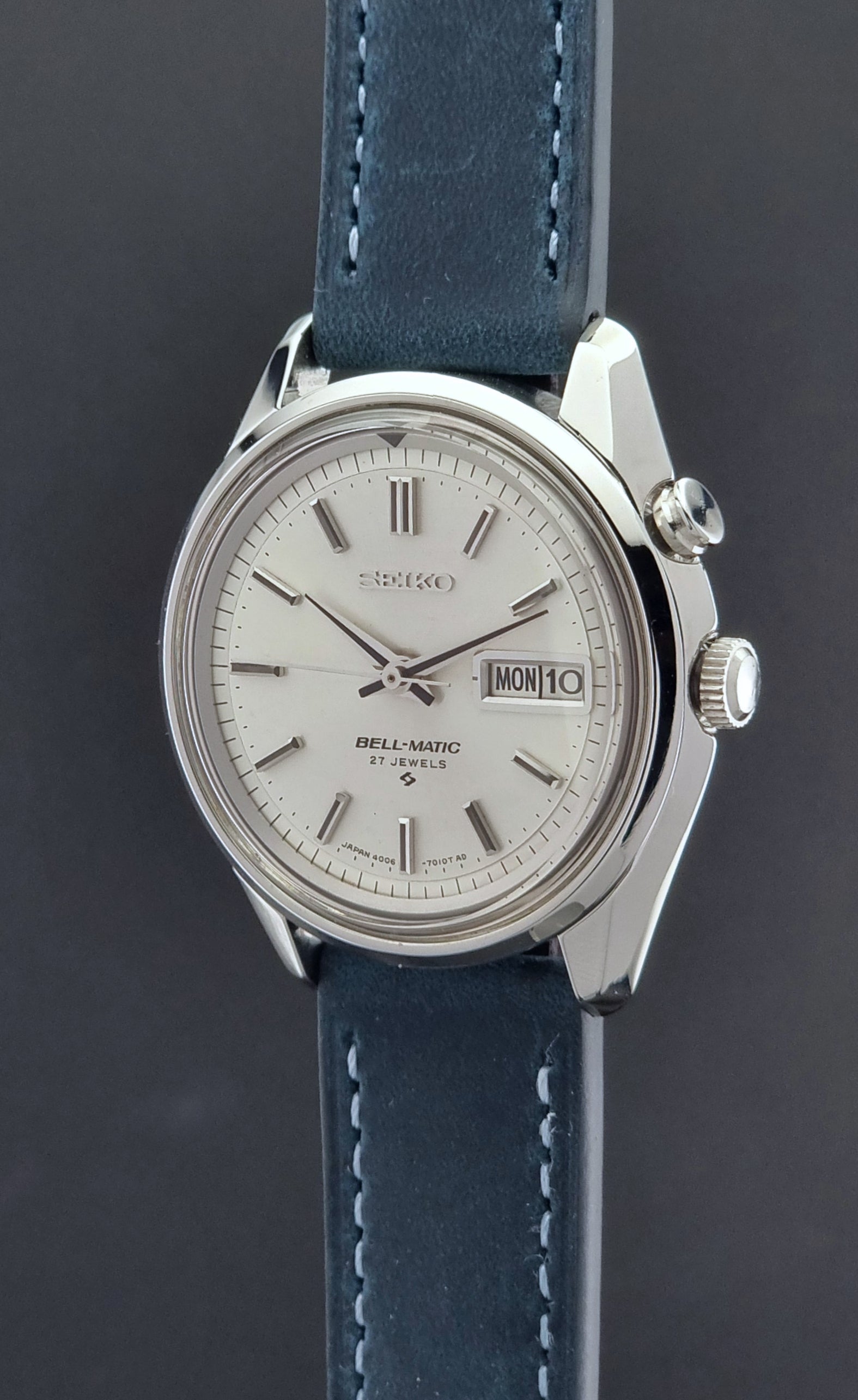 Vintage Seiko Alarm Watch Bell-Matic 4006-7010 with a blue strap on a grey background crown side profile