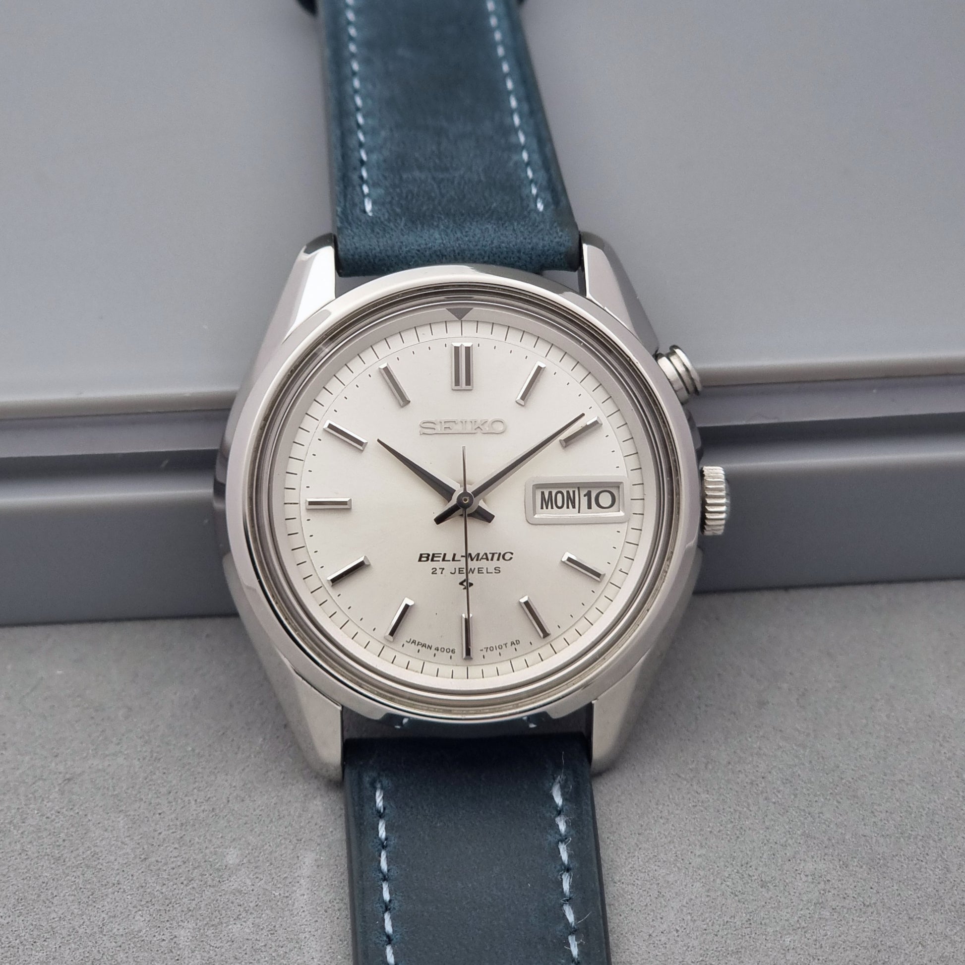 Vintage Seiko Alarm Watch Bell-Matic 4006-7010 with a blue strap on a grey background front