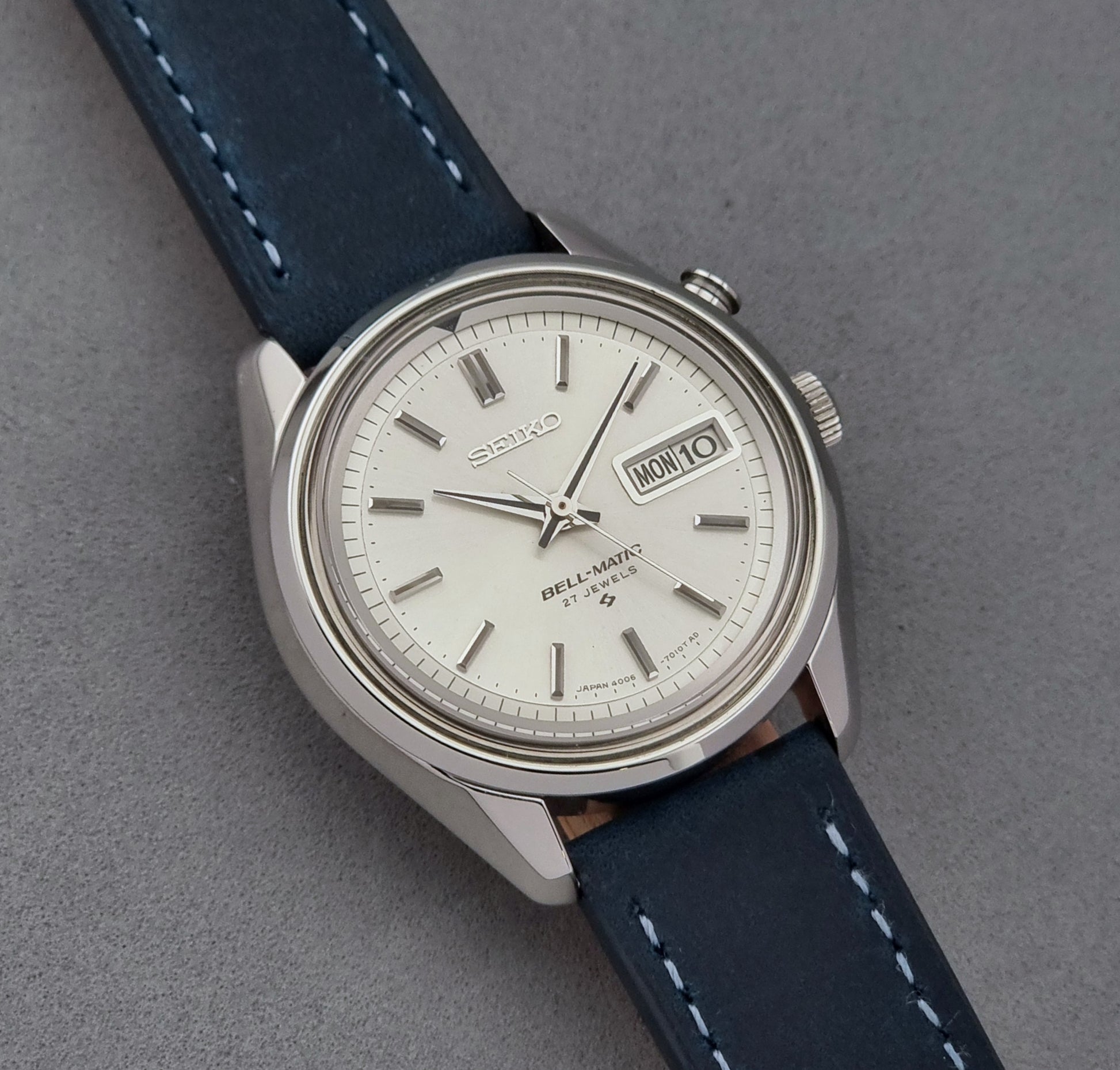 Vintage Seiko Alarm Watch Bell-Matic 4006-7010 with a blue strap on a grey background dial view