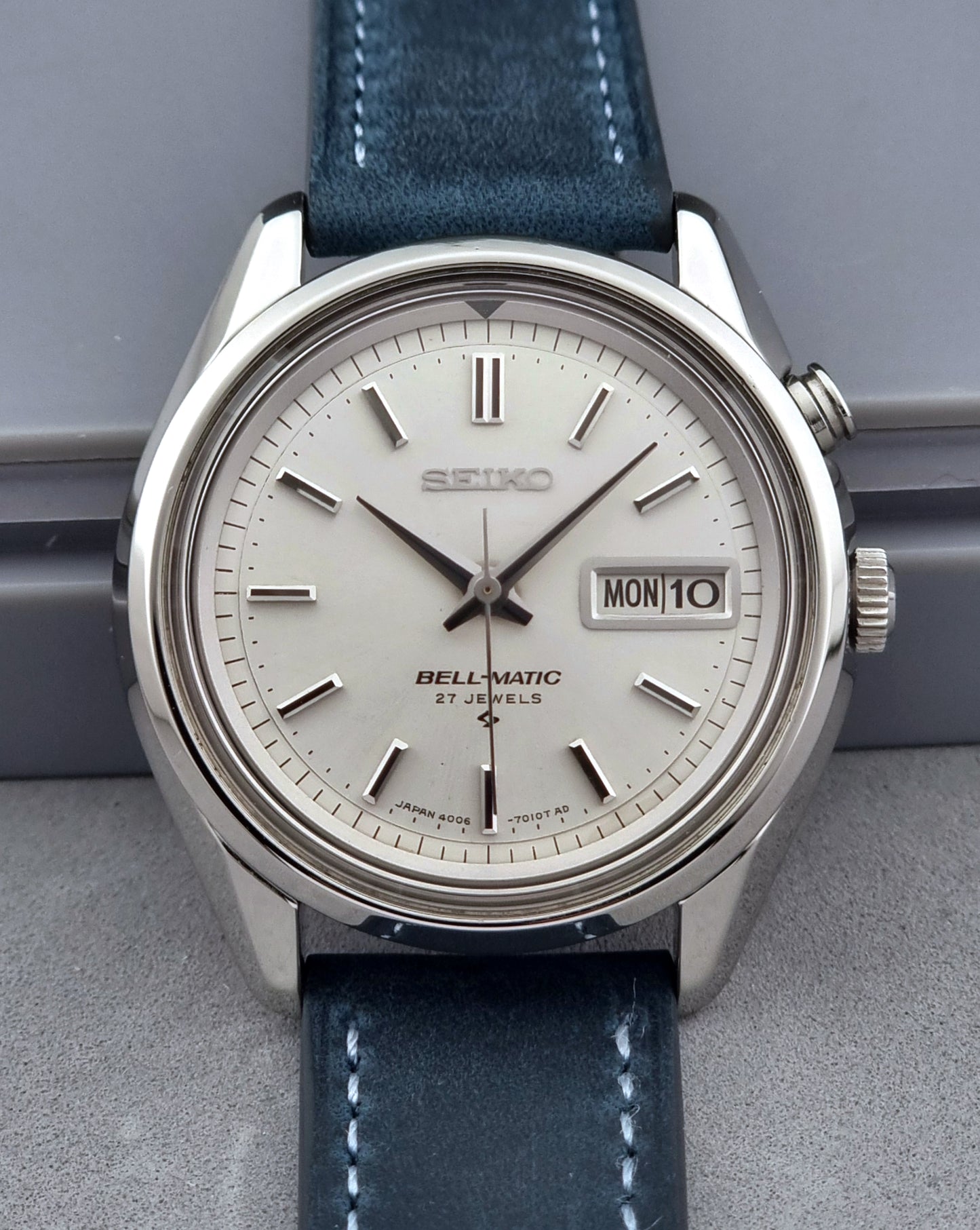 Vintage Seiko Alarm Watch Bell-Matic 4006-7010 with a blue strap on a grey background close up of the dial