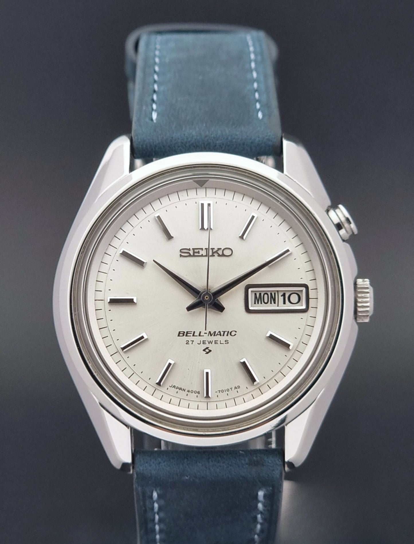 Vintage Seiko Alarm Watch Bell-Matic 4006-7010 with a blue strap on a grey background front view