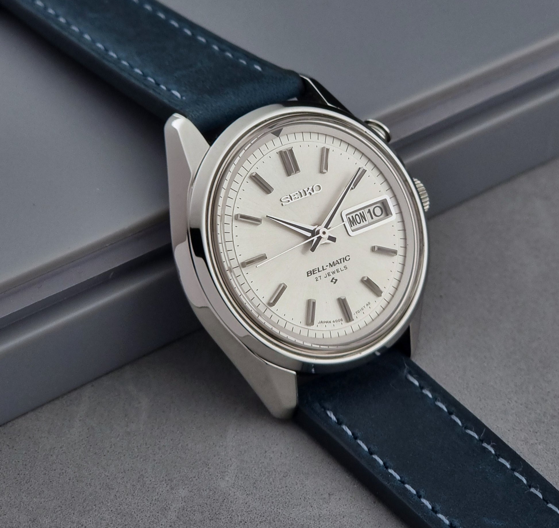 Vintage Seiko Alarm Watch Bell-Matic 4006-7010 with a blue strap on a grey background side profile