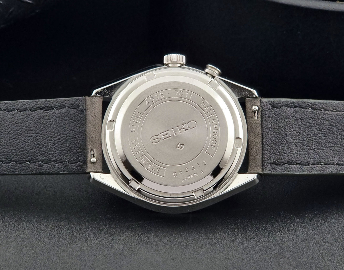 Vintage Seiko Alarm Wristwatch Bell-Matic 4006-7011 with a grey strap on a black background case back view