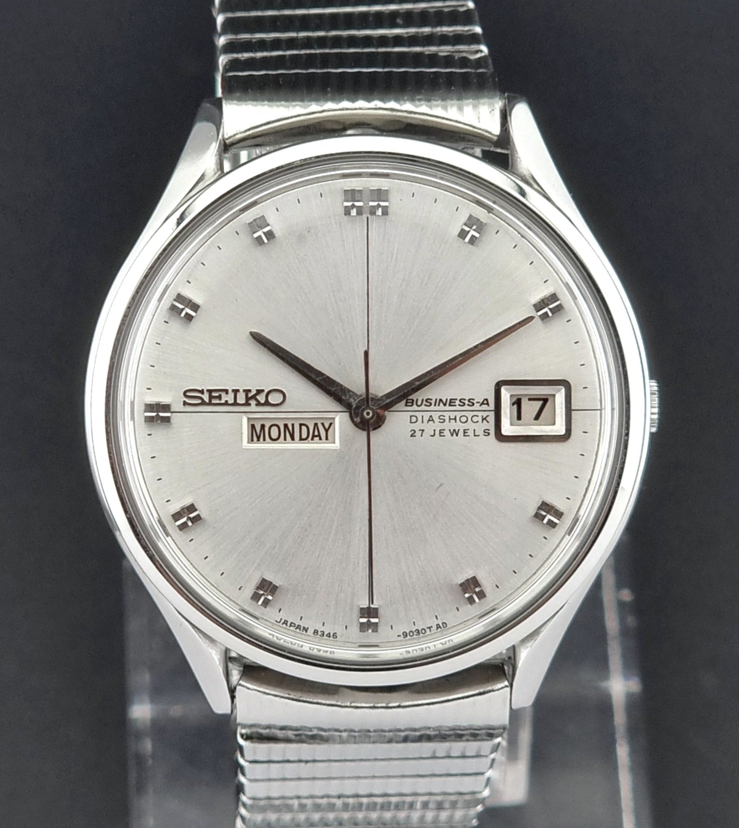 Silver Seiko wristwatch with a dark background