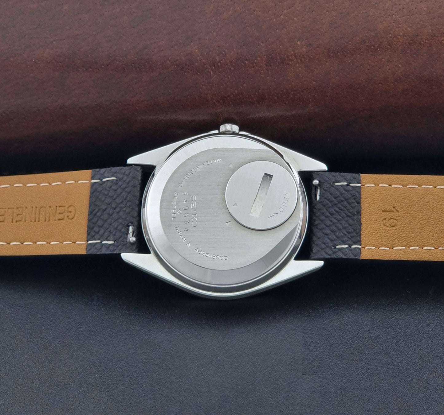 Vintage Seiko King Quartz watch 4823-8000 with black leather strap on a dark background case back view