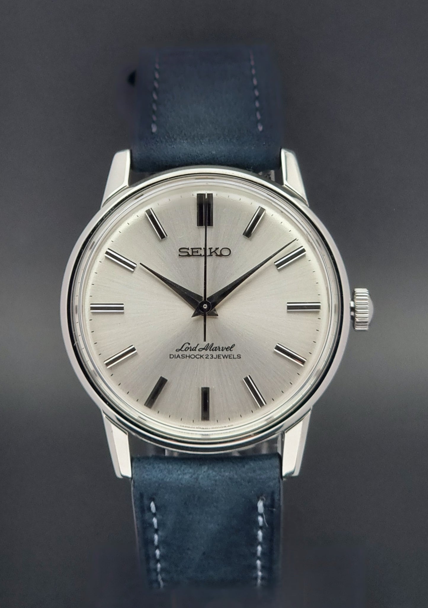 Vintage Seiko Lord Marvel wristwatch with blue leather strap on a dark background