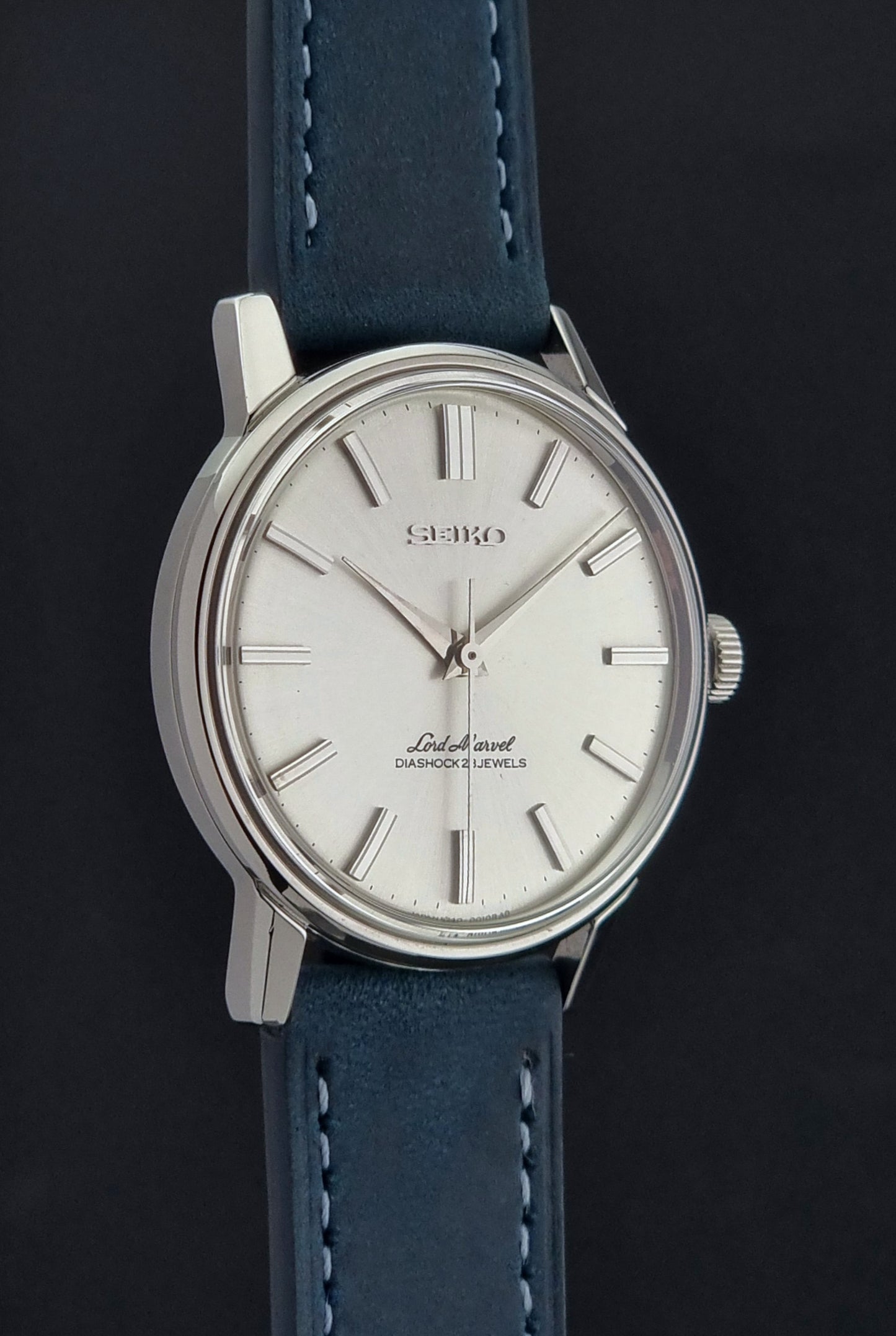 Seiko watch with blue leather strap on a black background