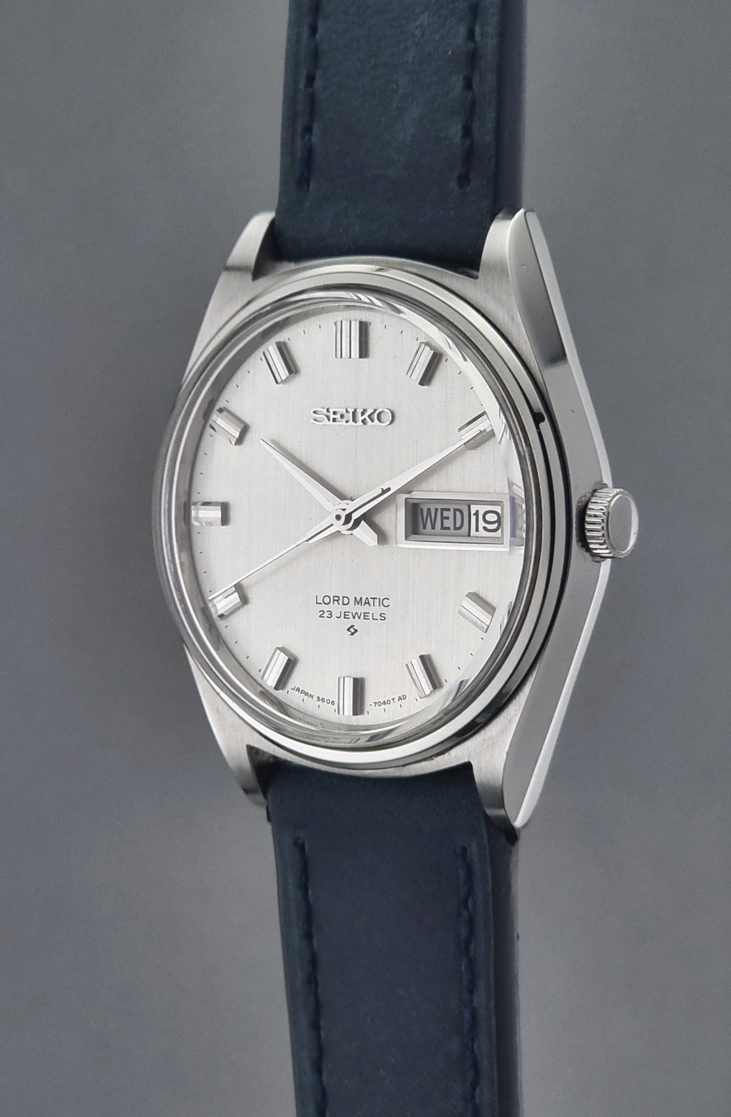 Seiko watch with blue leather strap on a gray background