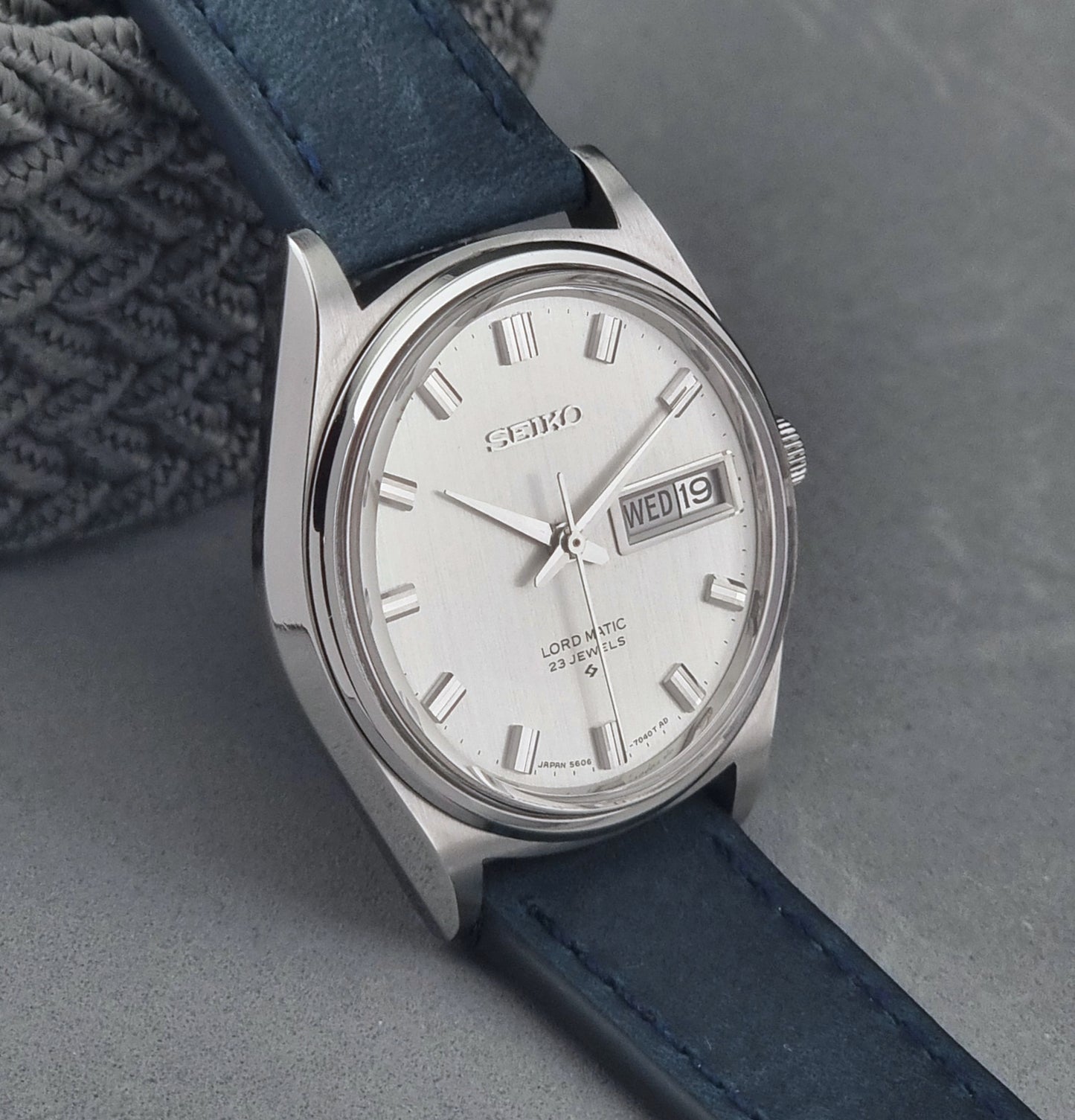 Vintage Seiko watch with blue strap on a gray background